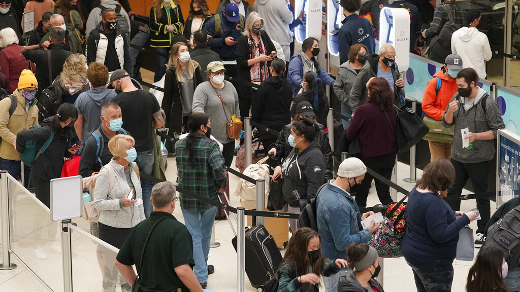 Passengers wait to pass through airport security