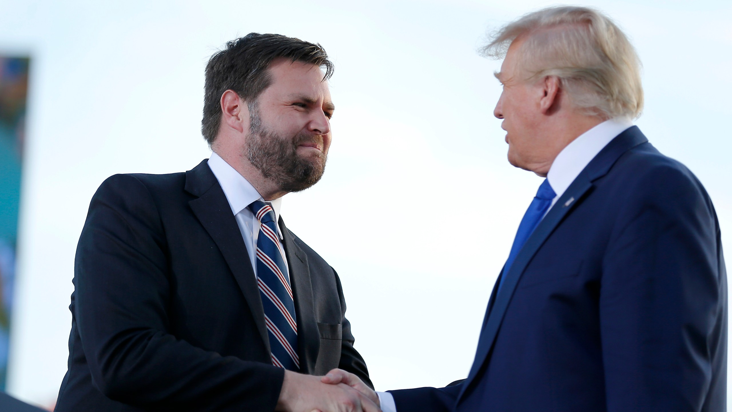JD Vance, left, greets former President Donald Trump at a rally in 2022.