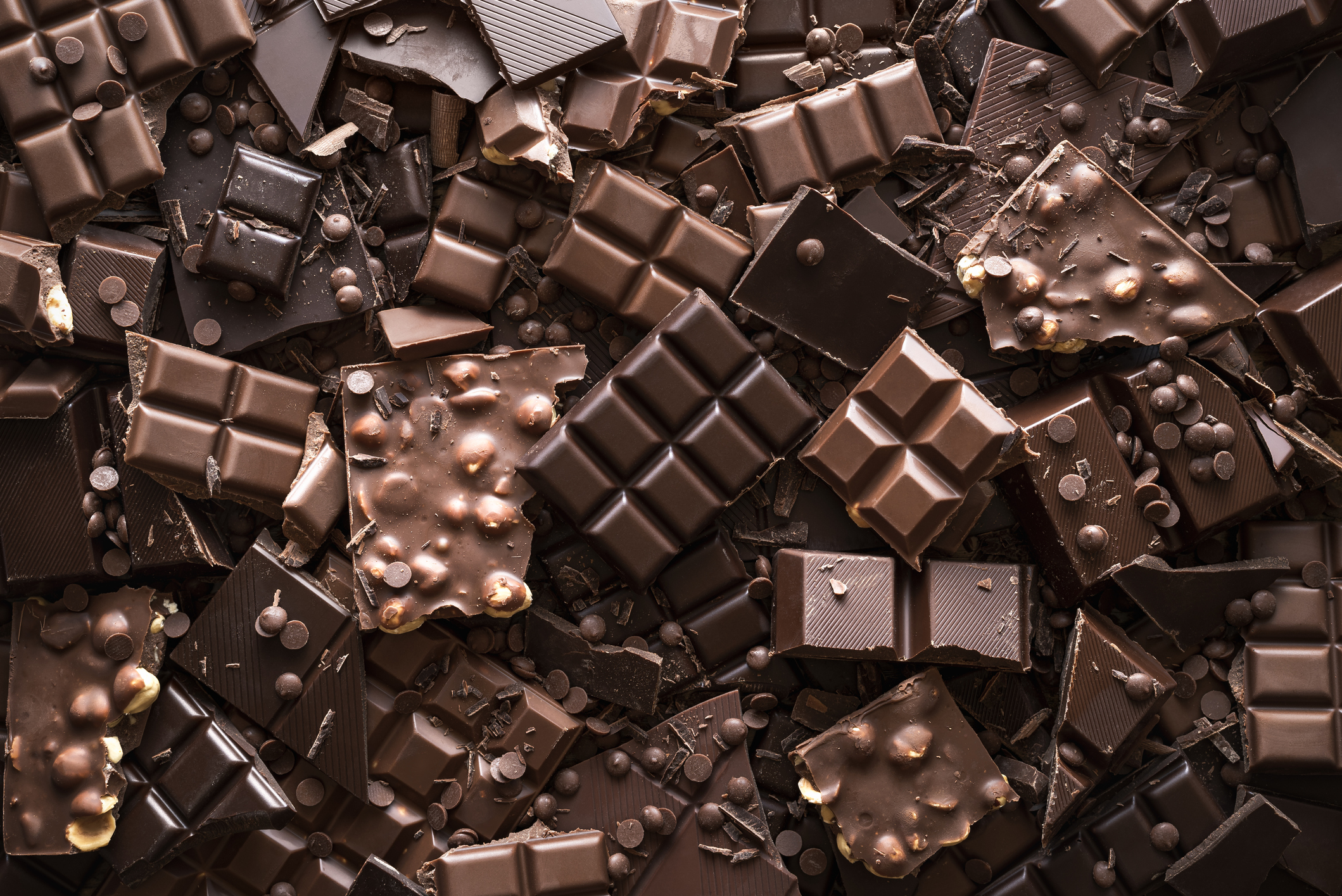Assorted chocolate bar and chunks, background. Flat lay with a multitude of chocolate kinds. Delicious cocoa dessert.