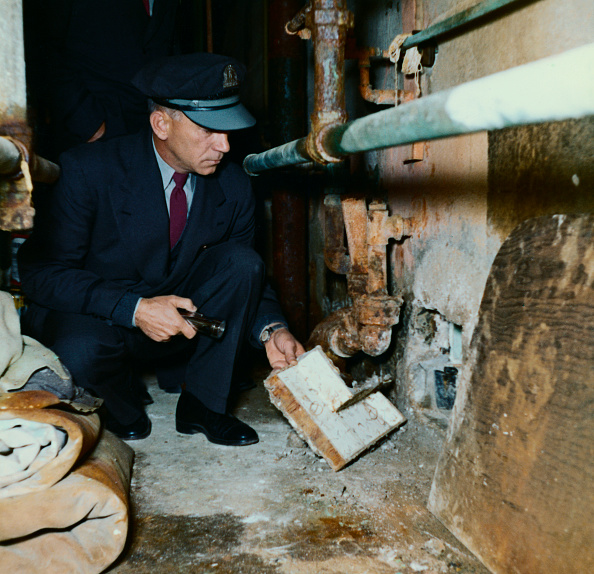 one of the cells in Cell Block B in Alcatraz Prison. An officer shows the inside of a removable section of exit cover.