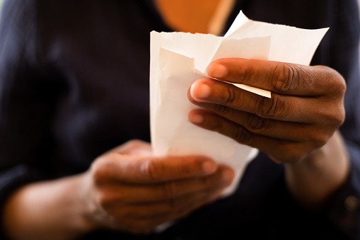 Person holding two paper receipts