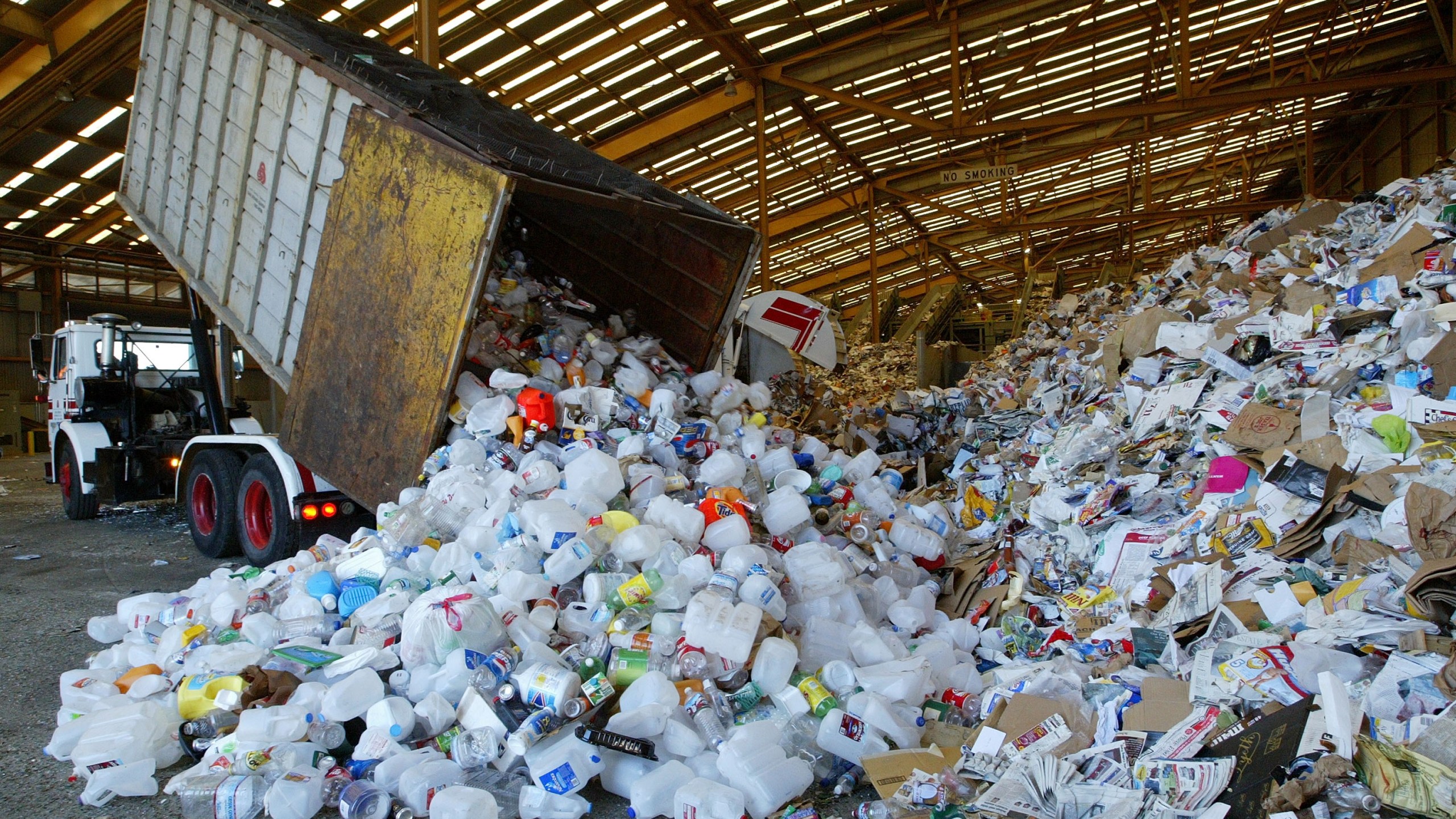 A truck dumps its load of recycled materials at a recycling facility