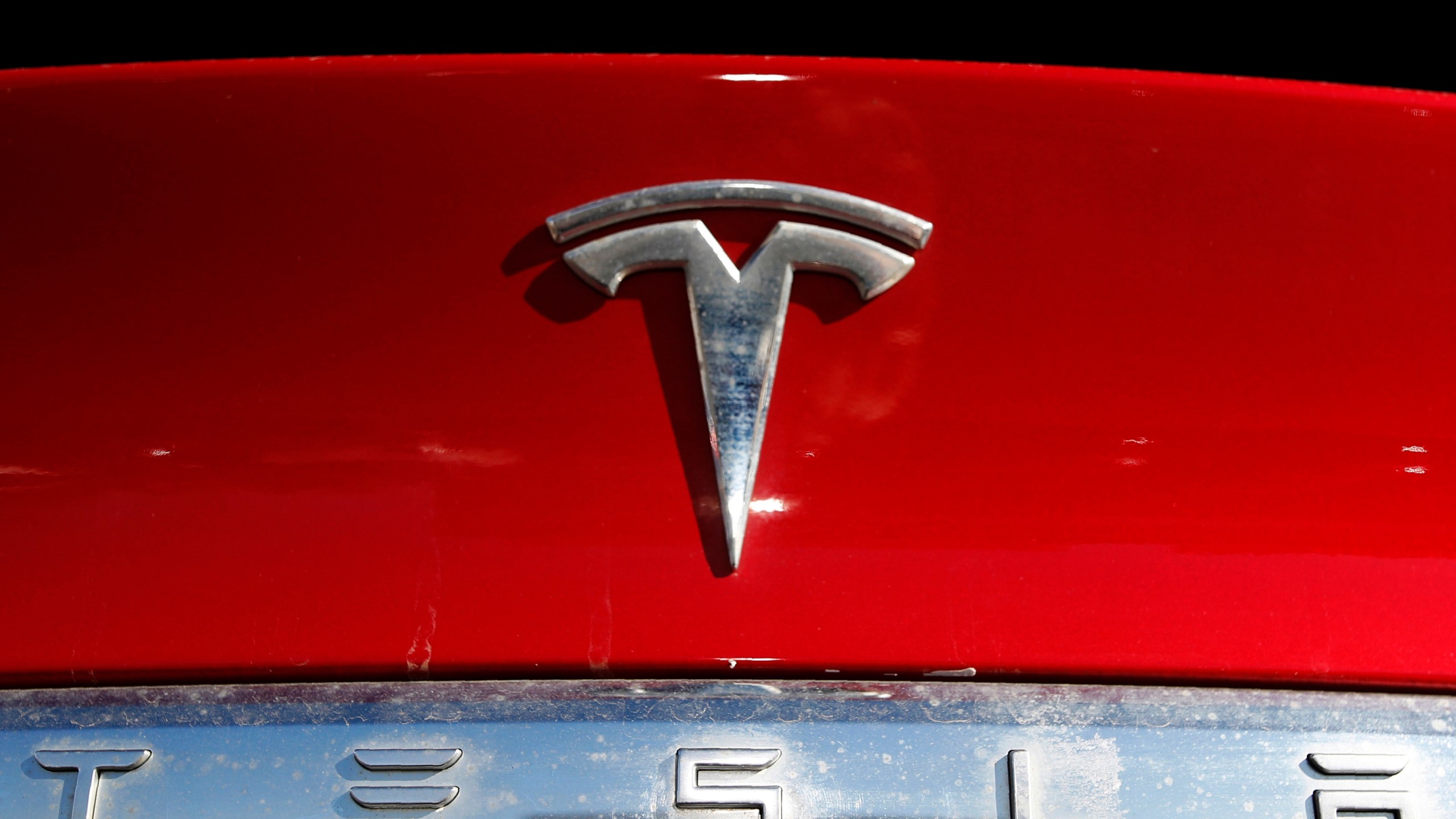FILE - The Tesla company logo sits on an unsold 2020 Model X at a Tesla dealership in Littleton, Colo., Feb. 2, 2020. The National Highway Traffic Safety Administration said Friday, April 7, 2023, that it will probe the March 15 crash in Halifax County, North Carolina, that injured a 17-year-old student. The State Highway Patrol said the driver of the 2022 Tesla Model Y, a 51-year-old male, failed to stop for the bus, which was displaying all of its activated warning devices. (AP Photo/David Zalubowski, File)