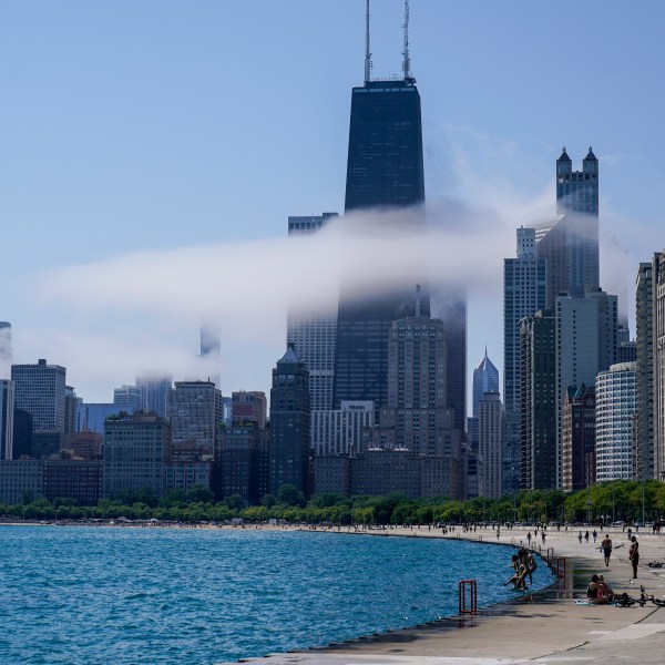The Chicago city skyline is covered by the fog lifted off Lake Michigan.
