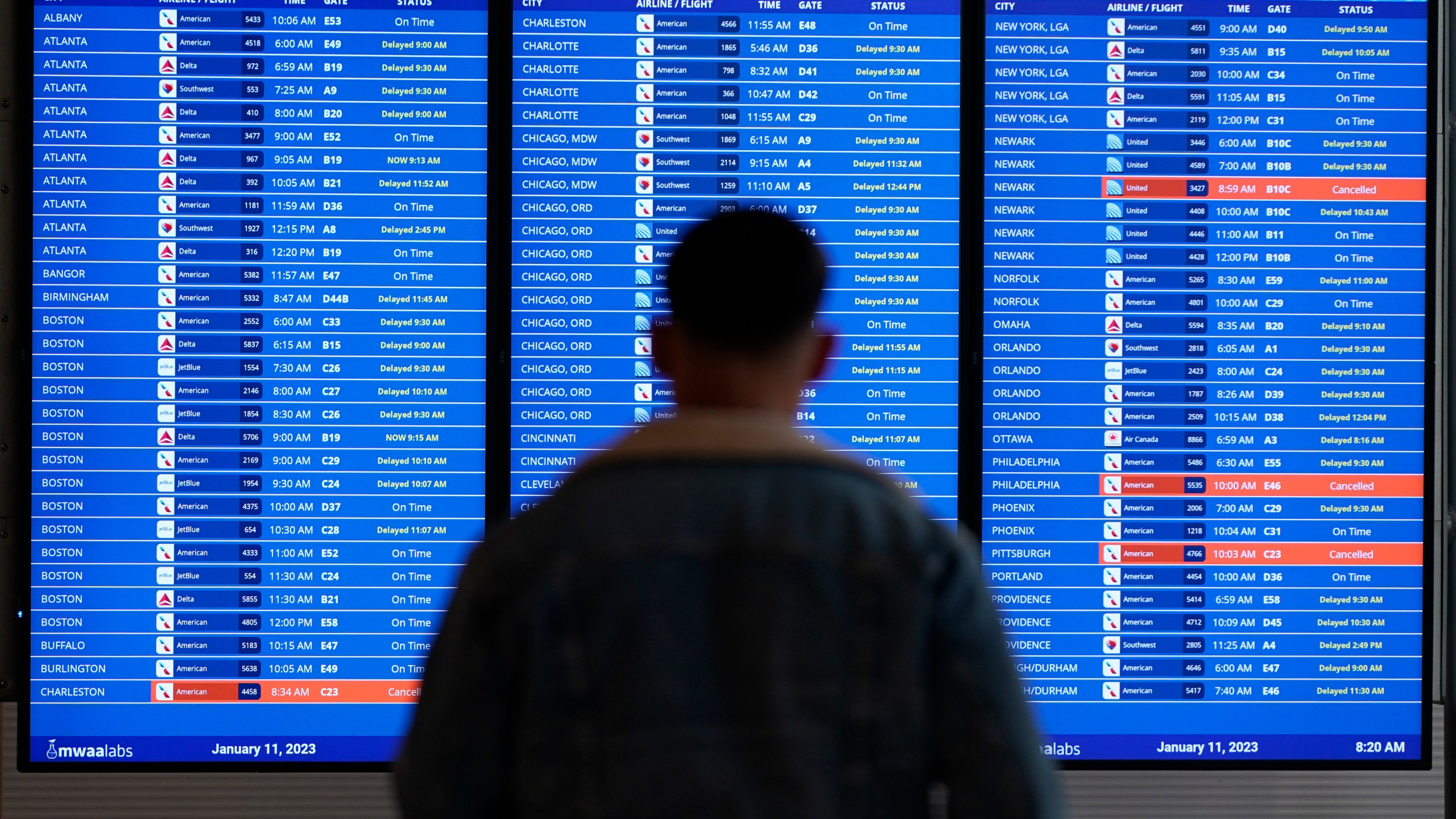 FILE - A traveler looks at a flight board with delays and cancellations at Ronald Reagan Washington National Airport in Arlington, Va., Wednesday, Jan. 11, 2023. Congressional investigators said in a report Friday, April 28, 2023, that an increase in flight cancellations as travel recovered from the pandemic was due mostly to factors that airlines controlled, including cancellations for maintenance issues or lack of a crew. (AP Photo/Patrick Semansky, File)