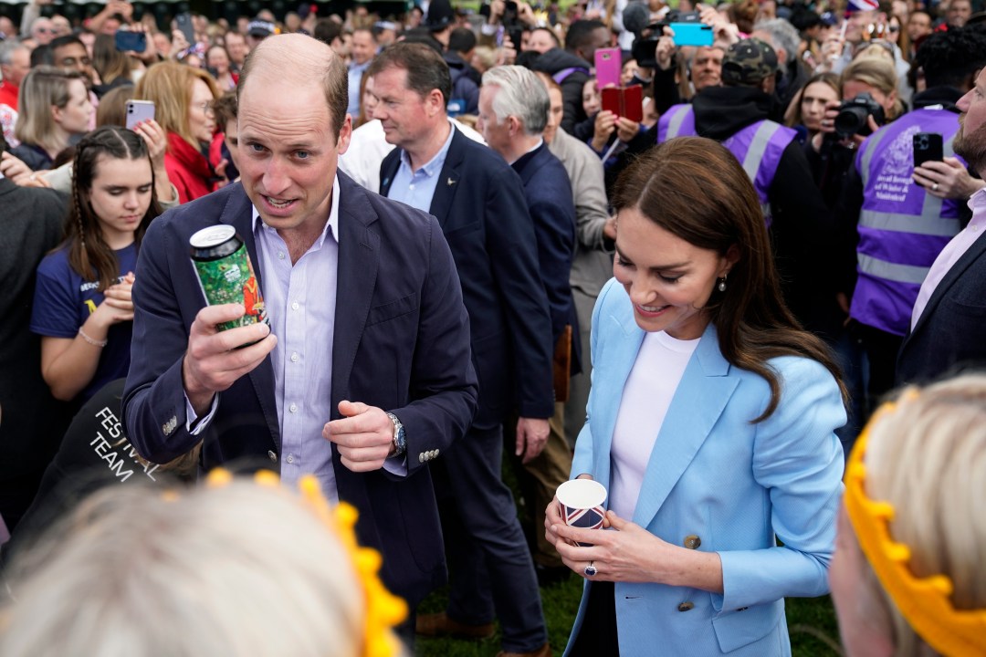 Britain's Prince William, the Prince of Wales, holds a can of Organic Coronation Ale, with Kate the Princess of Wales, during a walkabout meeting members of the public on the Long Walk near Windsor Castle where the Coronation Concert to celebrate the coronation of King Charles III and Queen Camilla is being held, in Windsor, England, Sunday May 7, 2023. (Andrew Matthews/Pool Photo via AP)
