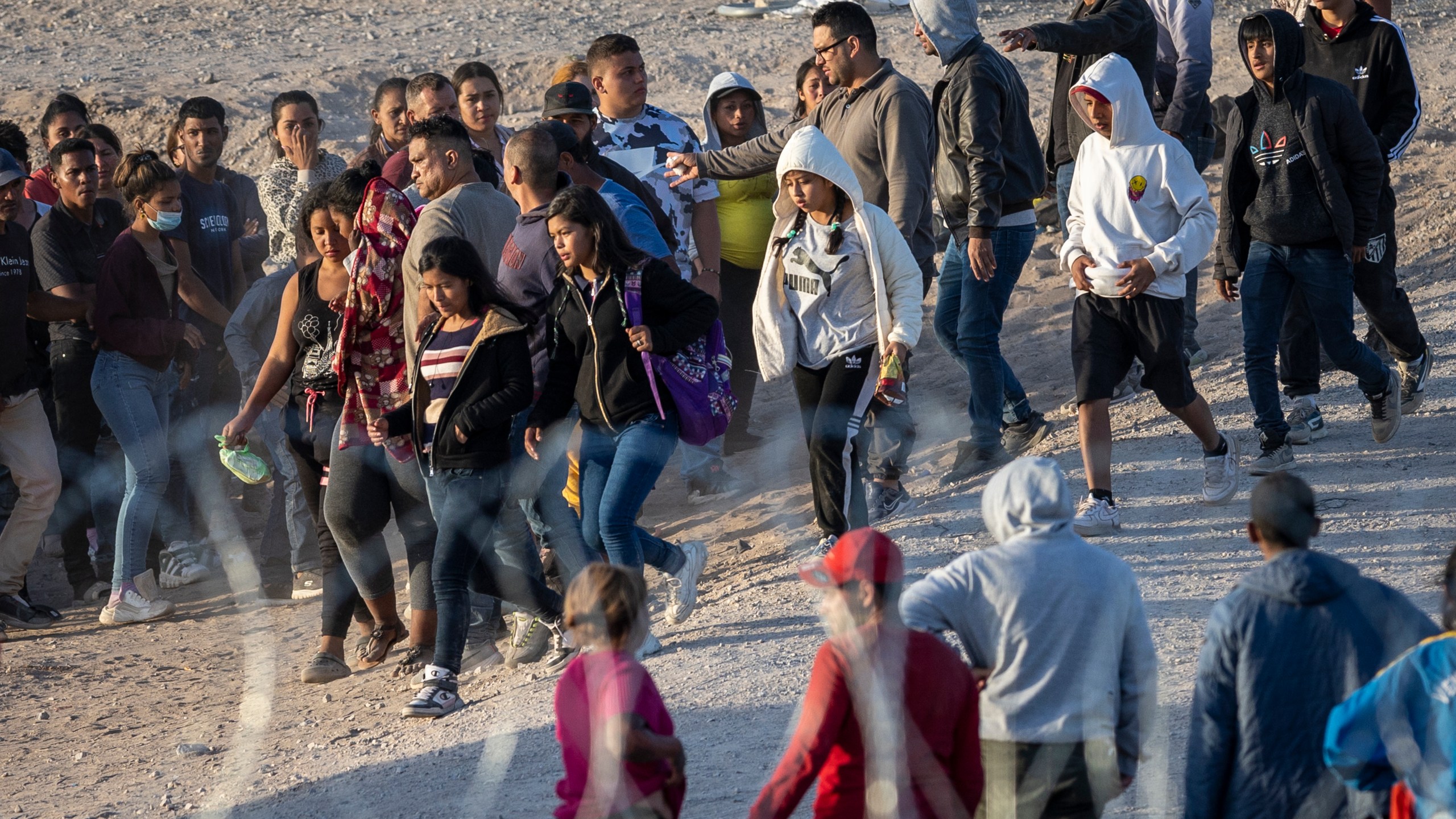 a group of children walks toward U.S. Border Patrol vehicles
