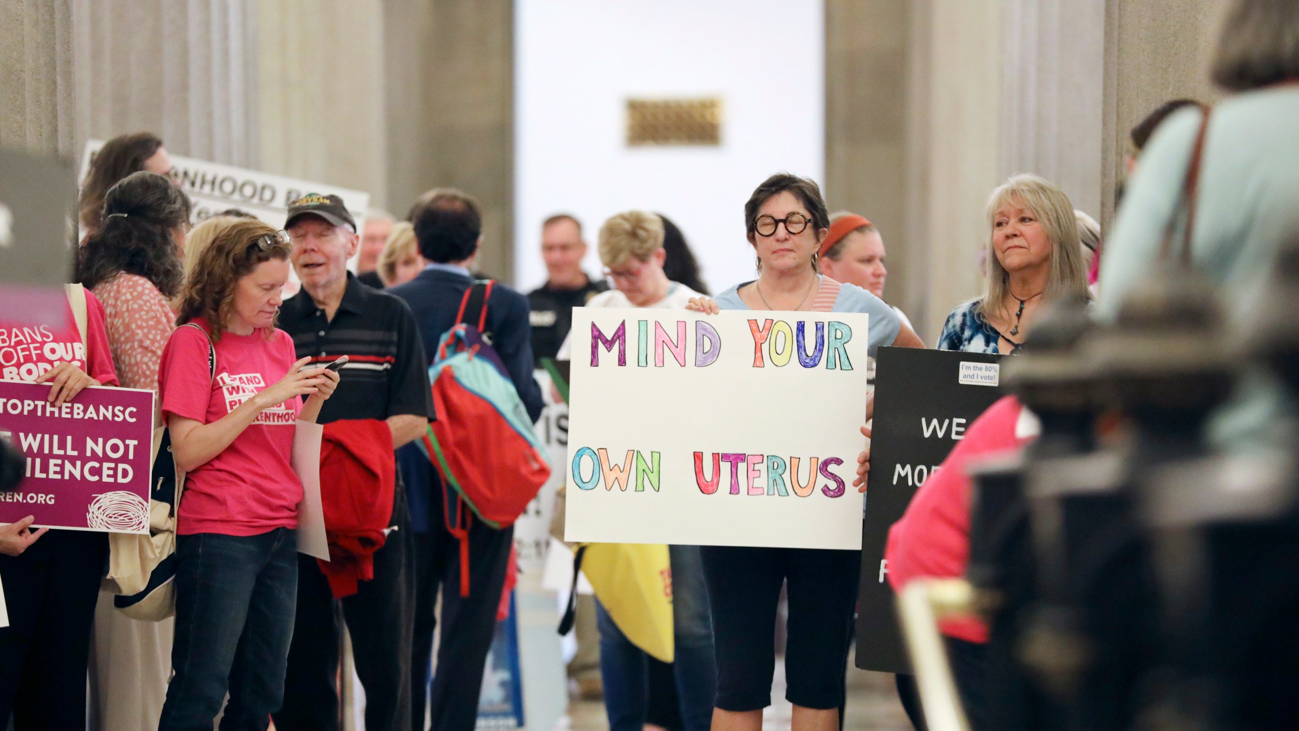 FILE - Protesters against a stricter ban on abortion in South Carolina stand in the Statehouse lobby on Tuesday, May, 23, 2023, in Columbia, South Carolina. South Carolina’s new all-male Supreme Court reversed course on abortion on Wednesday, Aug. 23, 2023, upholding a ban on most such procedures after about six weeks of pregnancy. (AP Photo/Jeffrey Collins, File)