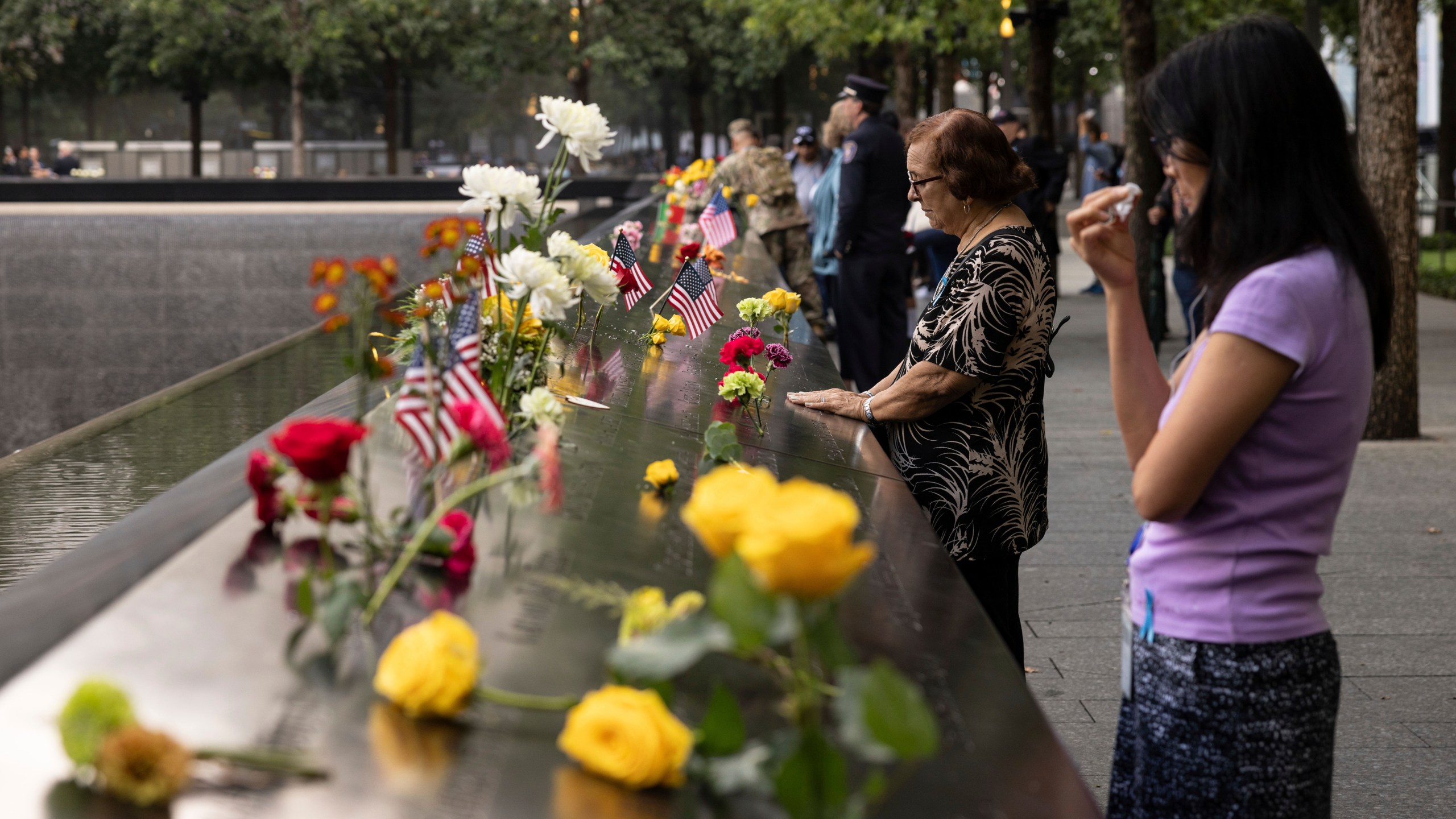 Family members put hands on the 9/11 Memorial during the commemoration ceremony on the 22nd anniversary of the September 11, 2001, terror attacks on Monday, Sept. 11, 2023, in New York. (AP Photo/Yuki Iwamura)