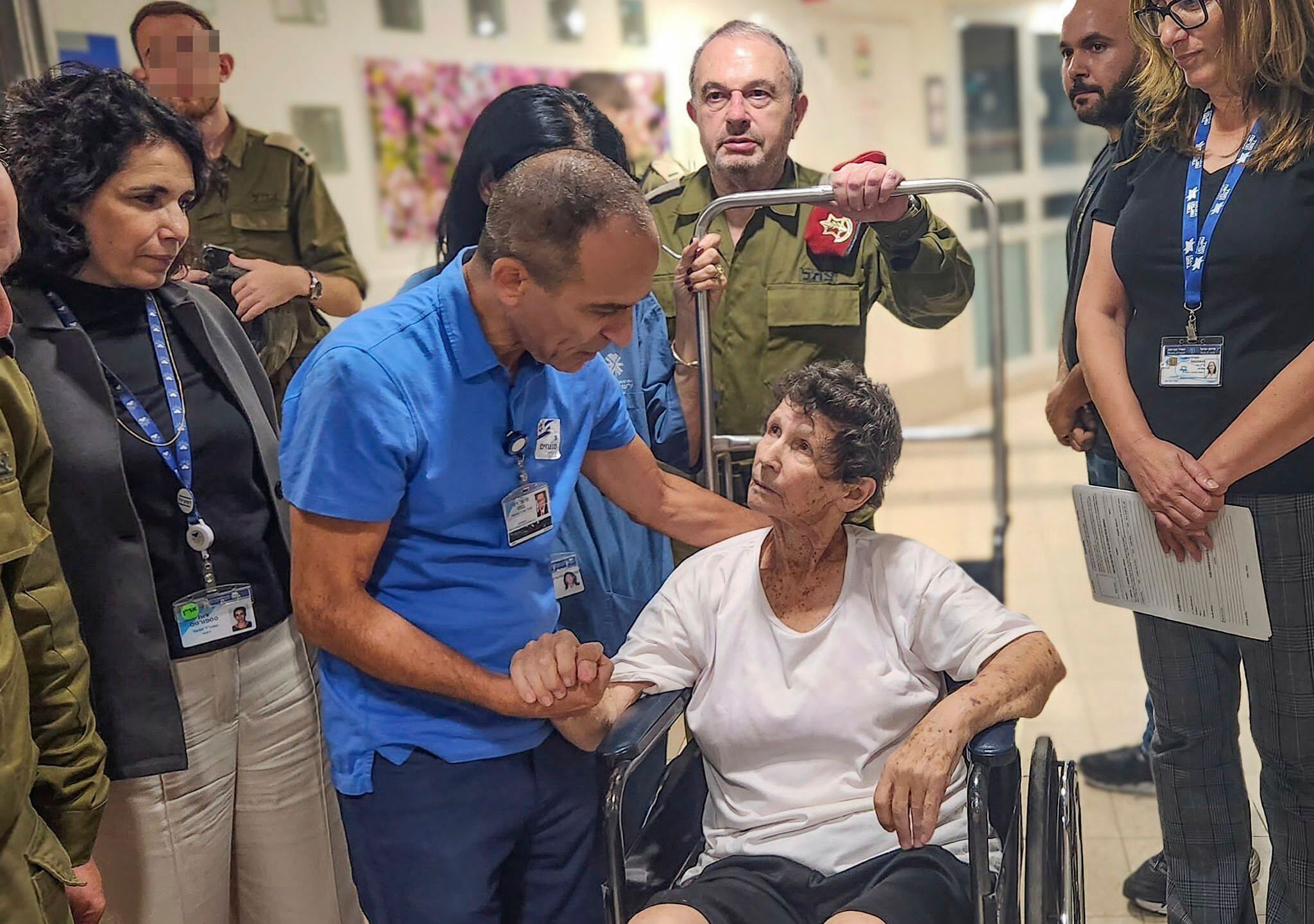 This photo provided by Ichilov hospital shows Yocheved Lifshitz, one of the two women released from Hamas captivity late Monday, Oct. 23, 2023, being wheeled in a wheelchair down the hall at the hospital in Tel Aviv, Israel. (Jenny Yerushalmy/Ichilov hospital via AP)
