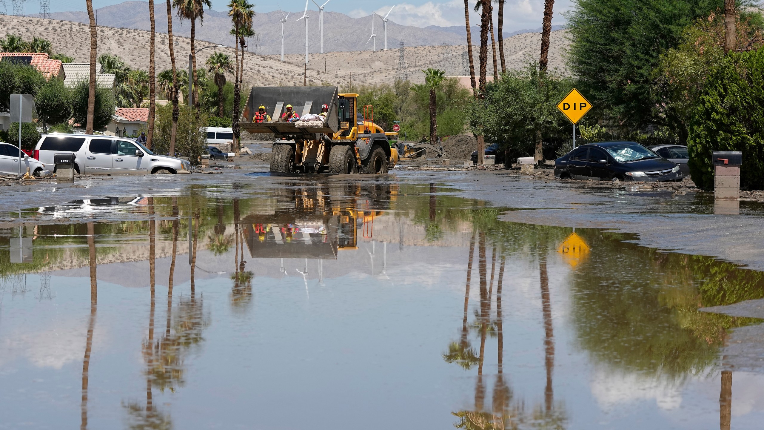 FILE - Firefighters use a skip loader to rescue people from an assisted living center after the street was flooded with mud following Tropical Storm Hilary, Aug. 21, 2023, in Cathedral City, Calif. A busy hurricane season that saw the National Hurricane Center in Miami issue the first ever tropical storm warning for the coast of California and hurricane warnings as far north as Nova Scotia is coming to a close Thursday night, Nov. 30. (AP Photo/Mark J. Terrill, File)
