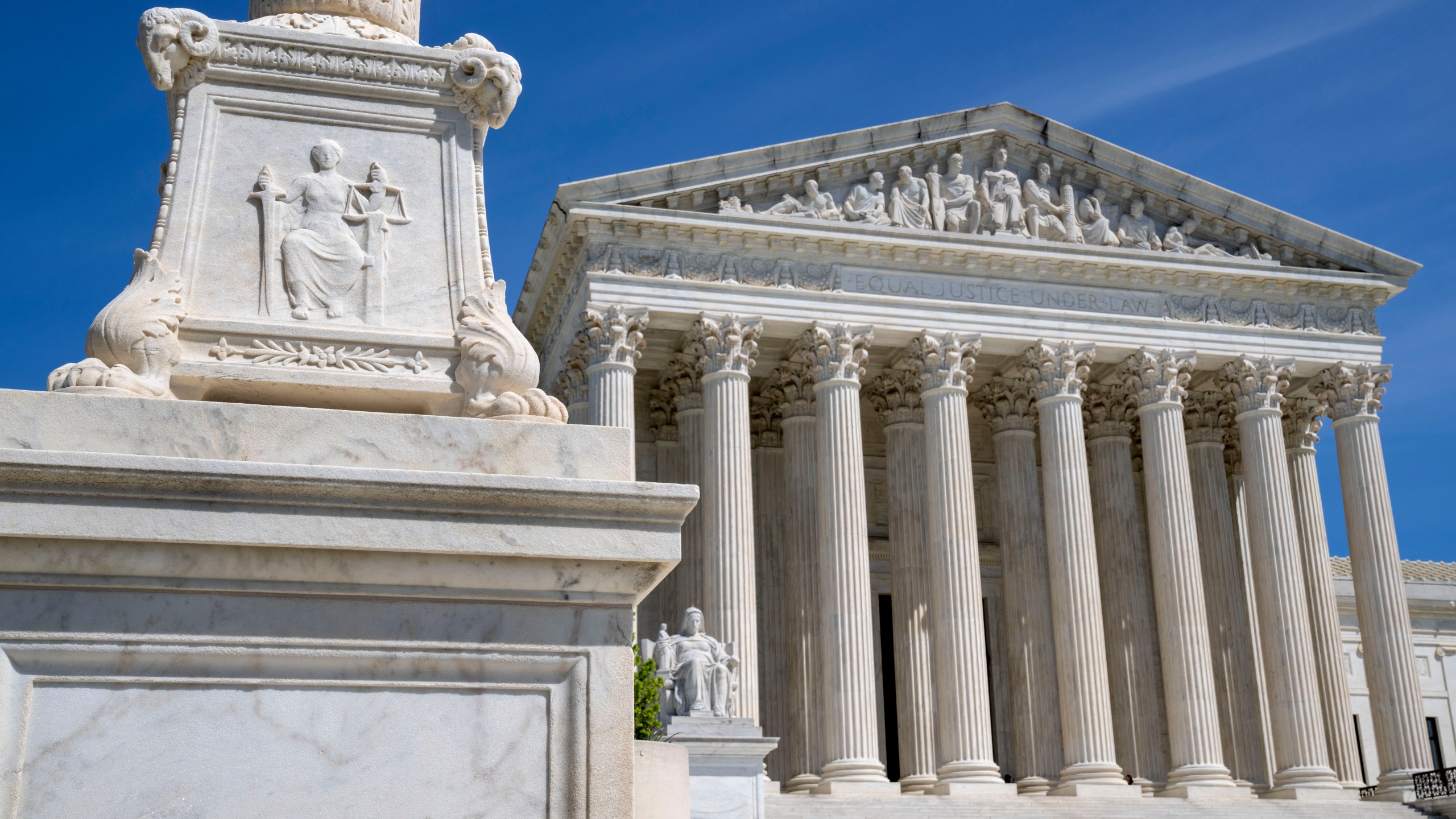 FILE - The U.S. Supreme Court is seen, with a carving of Justice in the foreground, April 19, 2023, in Washington. A Black Ohio woman who miscarried in her bathroom has been charged with abuse of a corpse and awaits grand jury action. Her case has sparked a national firestorm over the plight of pregnant women, especially women of color, following the U.S. Supreme Court’s decision to overturn Roe v. Wade. (AP Photo/Jacquelyn Martin, File)