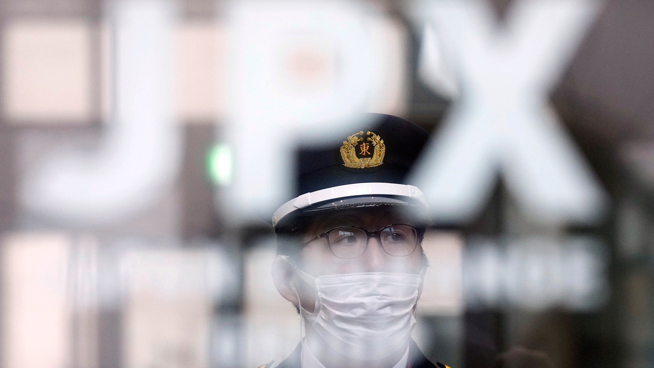 A security guard stands guard at the gate of the Tokyo Stock Exchange Thursday, Jan. 4, 2024, in Tokyo, after a ceremony marking the start of this year's trading. Asian stocks plunged Thursday, echoing the pessimism on Wall Street as the Tokyo exchange marked the first day of trading for the year with a broad slide. (AP Photo/Eugene Hoshiko)