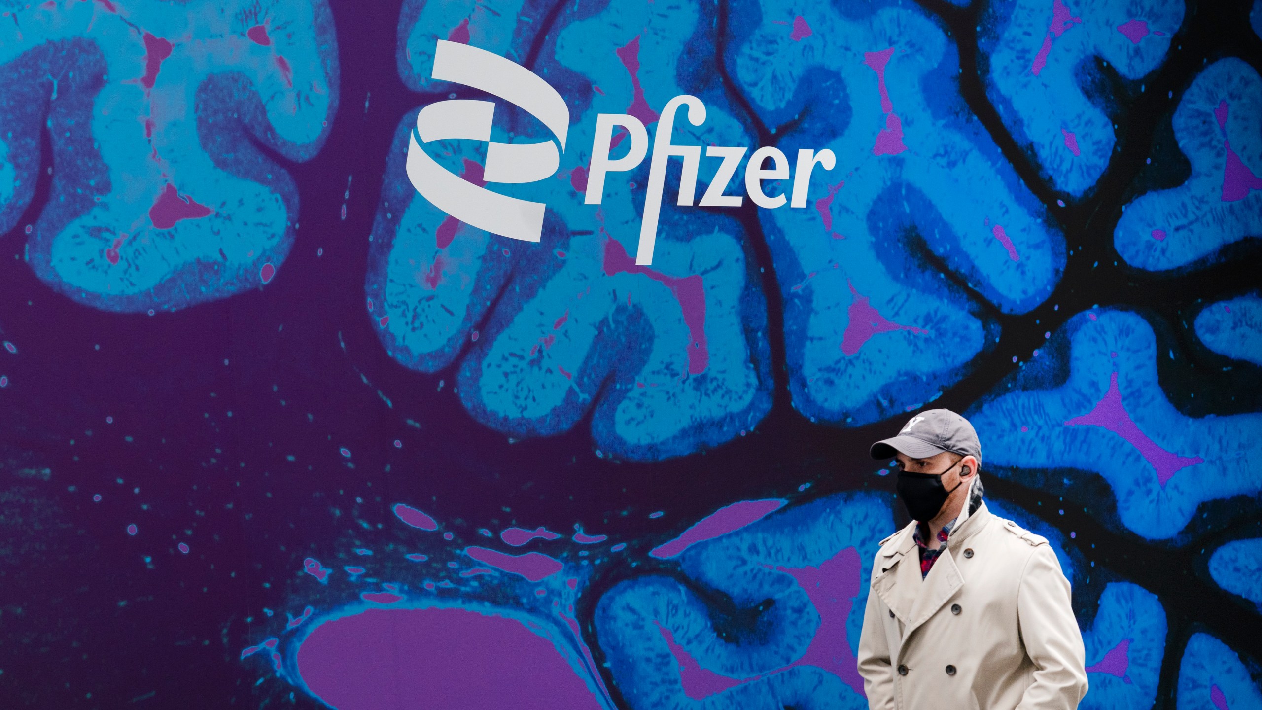 A man walks by Pfizer headquarters in New York.