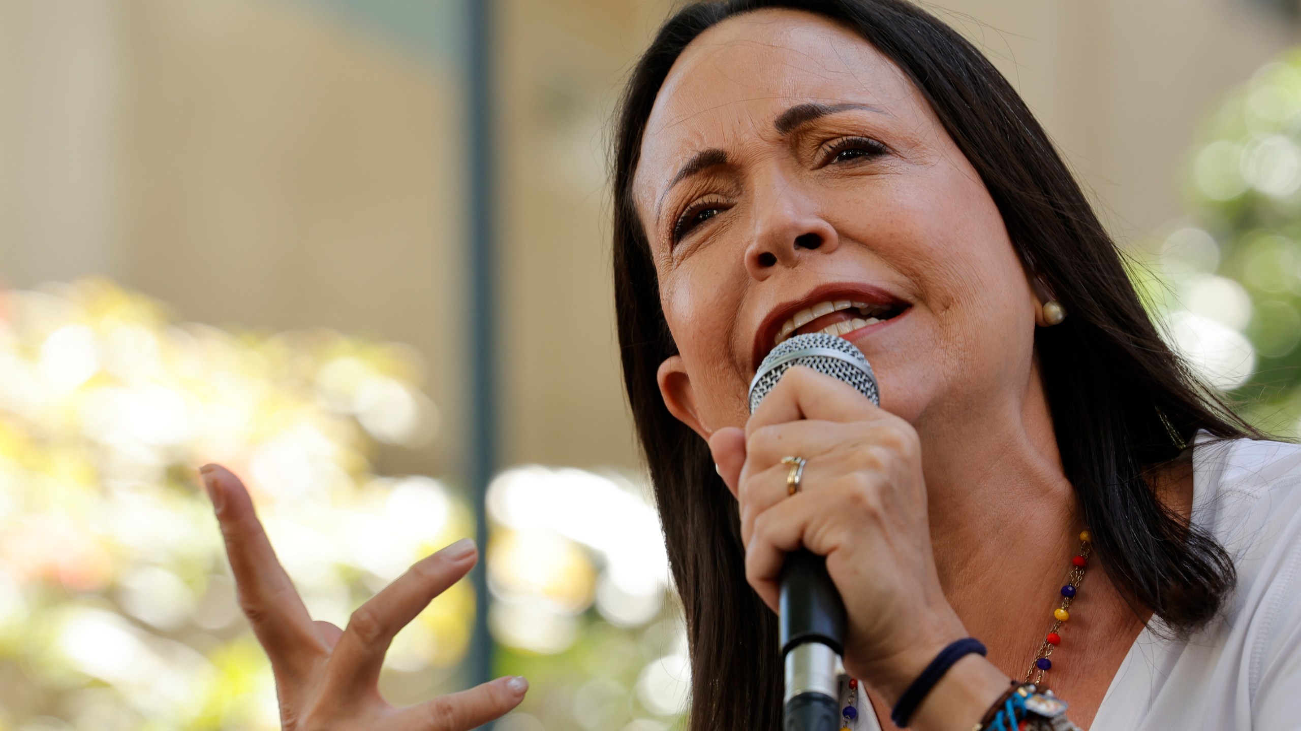 María Corina Machado speaks into a microphone