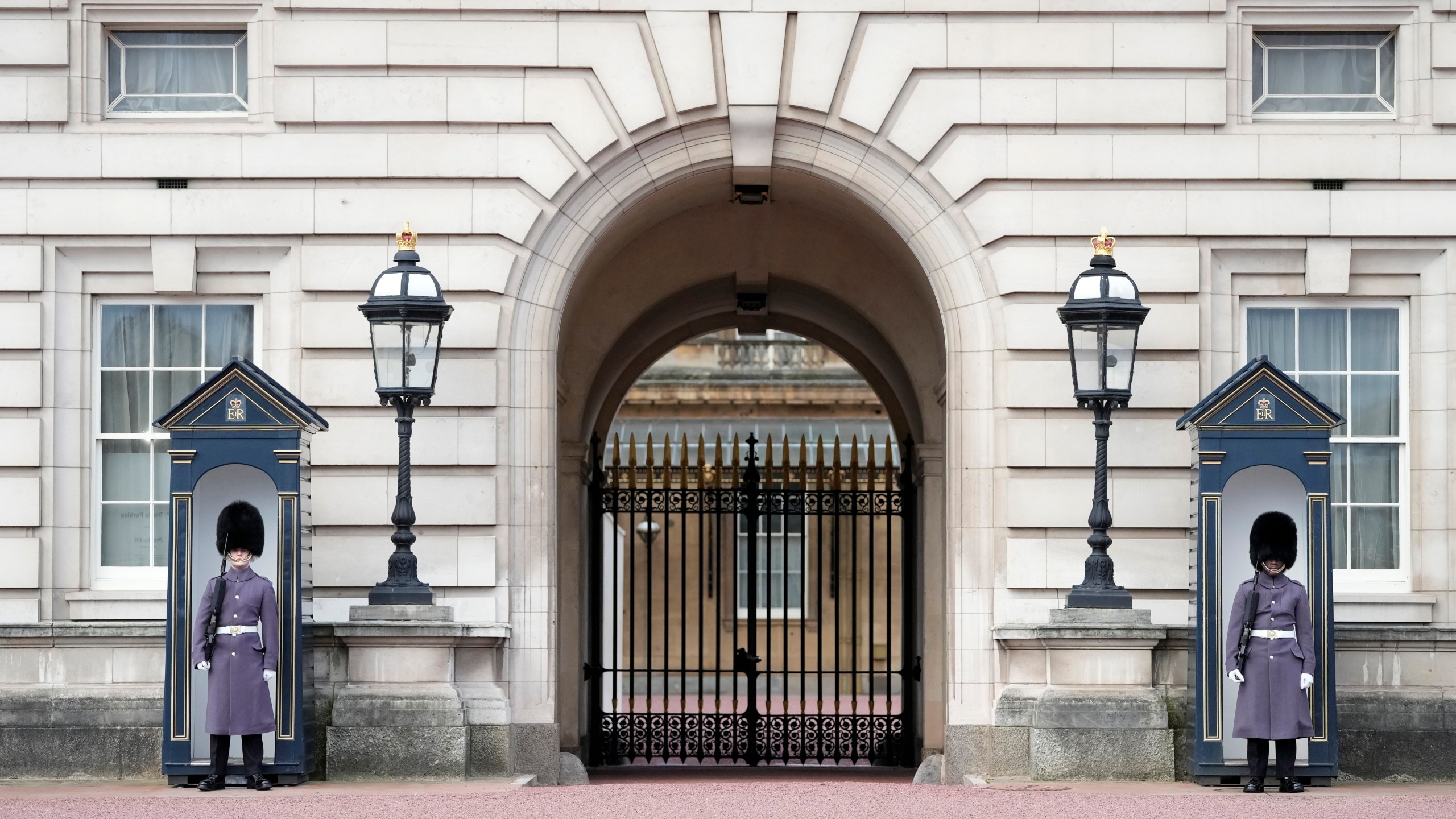 Two soldiers on guard outside Buckingham Palace one, of the official residences of King Charles III, in London, Tuesday, Feb. 6, 2024. Buckingham Palace says King Charles III has begun outpatient treatment for cancer, the statement issued Monday did not say what type of cancer he has. (AP Photo/Kin Cheung)