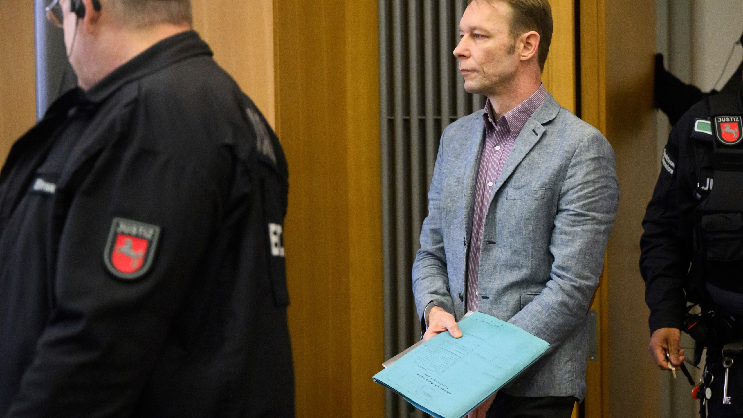 FILE - Christian B. centre, arrives at the start of his trial, at Braunschweig district court, in Brunswick, Germany, on Feb. 16, 2024. A man who is also under investigation in the disappearance of British toddler Madeleine McCann won't respond to unrelated charges of sexual offenses at a trial that opened last week in Germany, his lawyer said Friday, Feb. 23, 2024. (Julian Stratenschulte/dpa via AP, File)