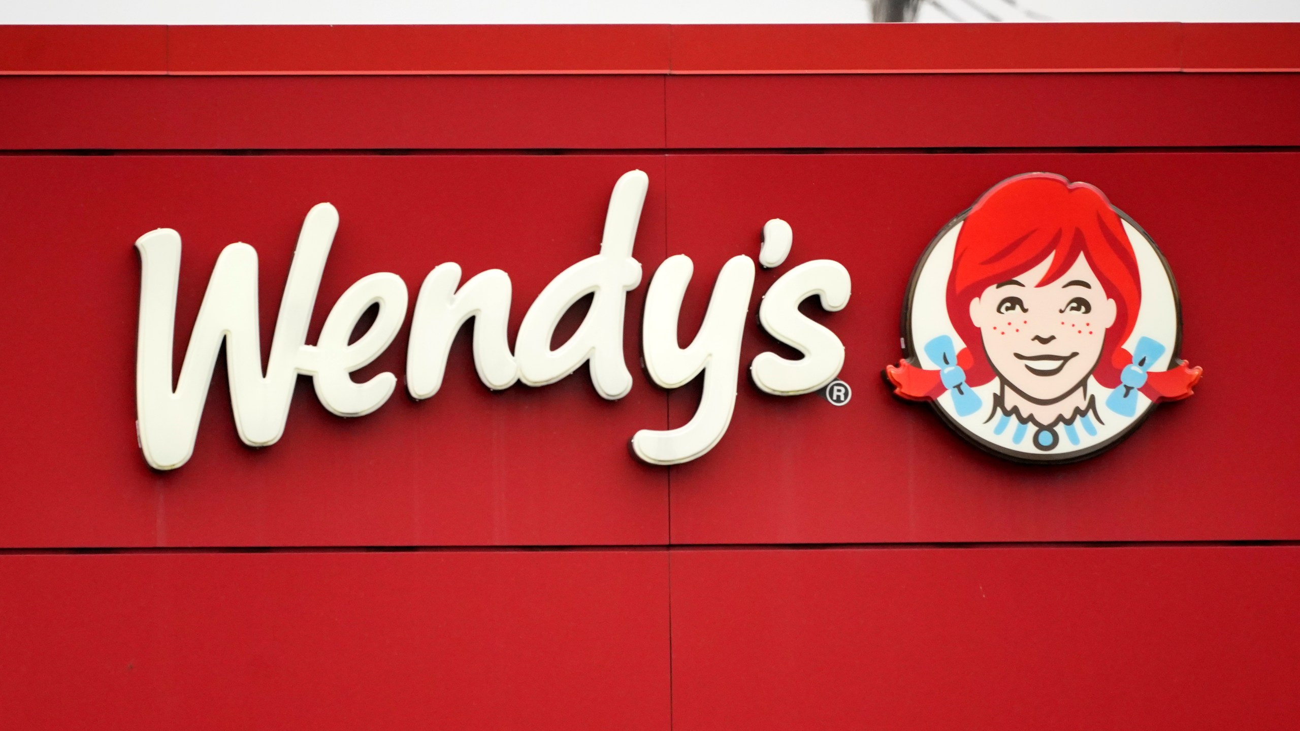 FILE - The Wendy's sign is seen at a restaurant, Jan. 23, 2023, in Pittsburgh. Wendy's is looking to test having the prices of its menu items fluctuate throughout the day based on demand, implementing a strategy that has already taken hold with ride-sharing companies and ticket sellers. (AP Photo/Gene J. Puskar, File)