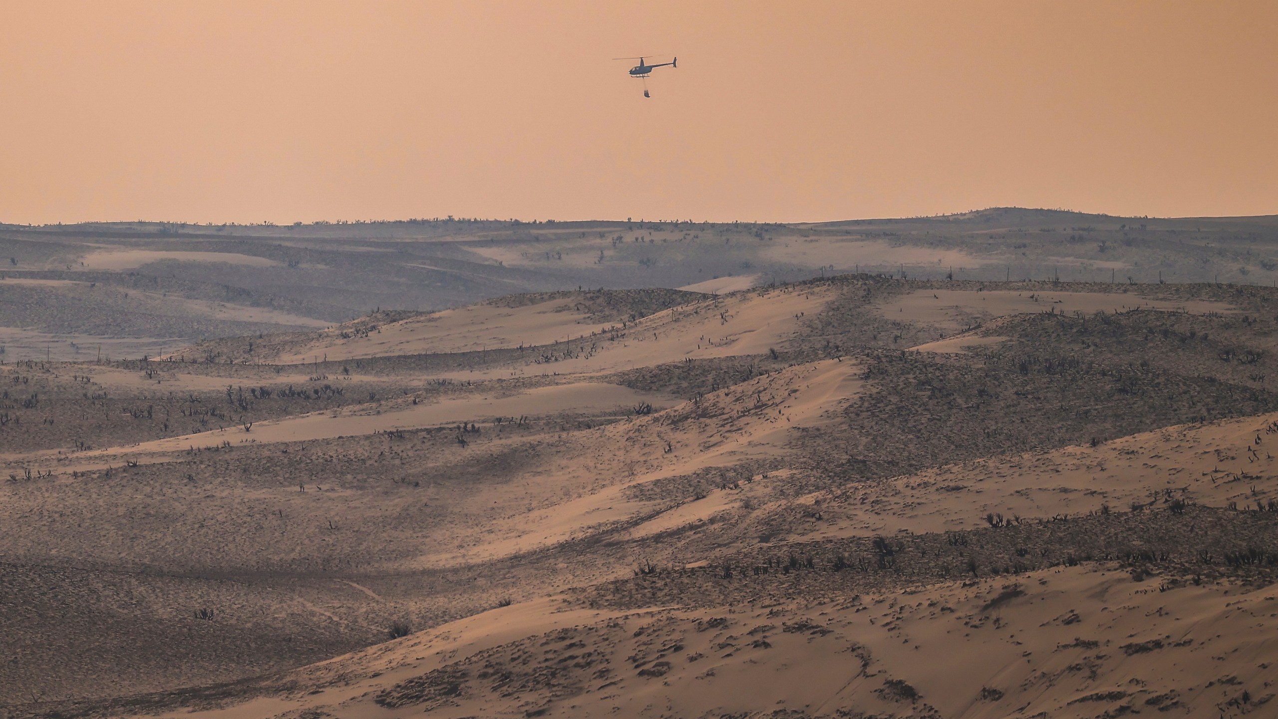 A helicopter returns from dumping water on hotspots from the Smokehouse Creek Fire, Wednesday, Feb. 28, 2024, in Canadian, Texas. (AP Photo/David Erickson)