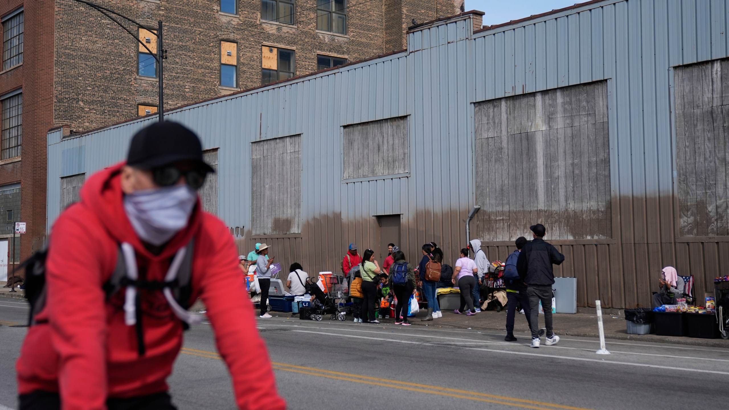 People hang around outside of a migrant shelter Wednesday, March 13, 2024, in the Pilsen neighborhood of Chicago.