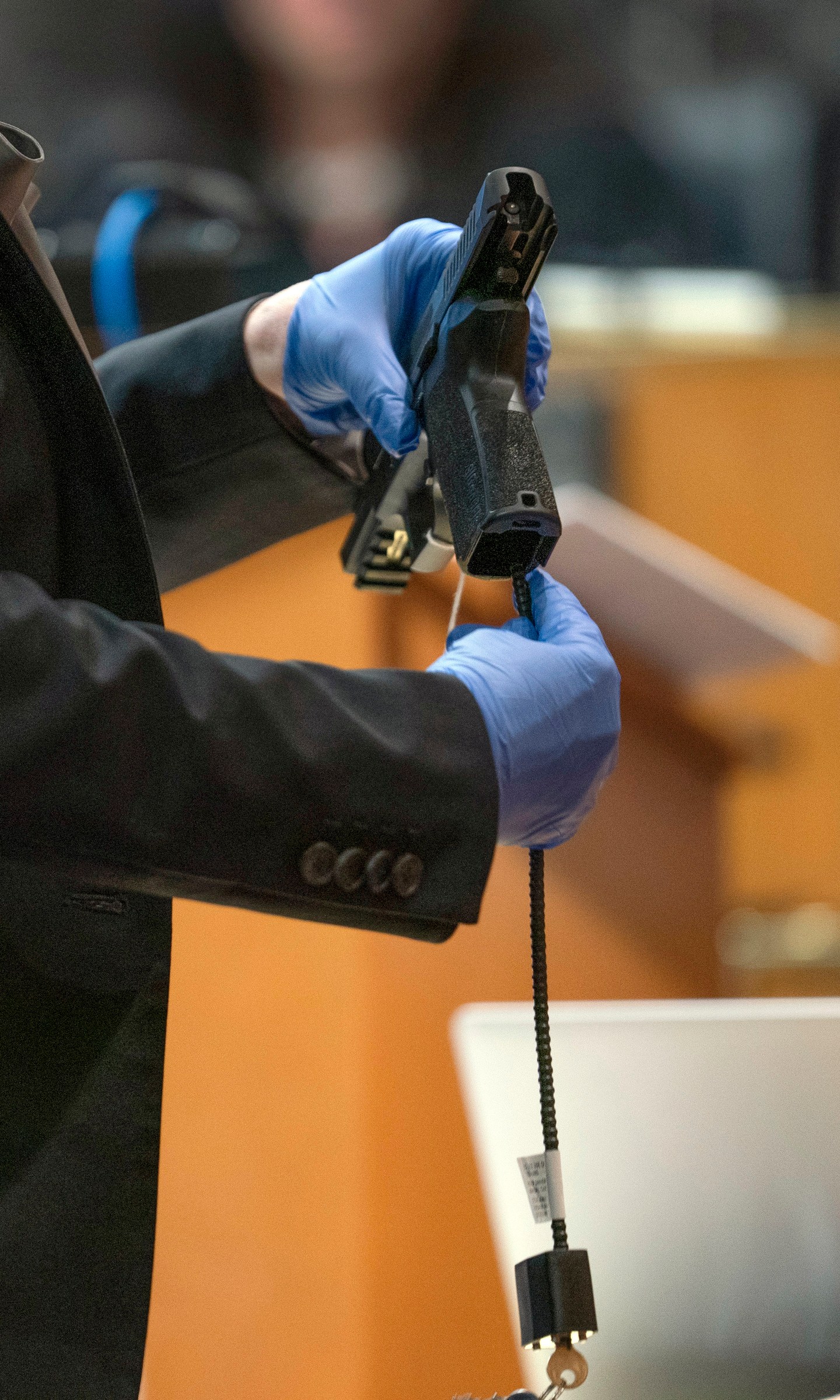 Oakland County Prosecutor Karen McDonald demonstrates how swiftly she was able to insert a gun lock during closing statements in the trial of James Crumbley, Wednesday, March, 13, 2024 in Pontiac, Mich. Crumbley is charged with involuntary manslaughter, accused of failing to secure a gun at home and ignoring his son's mental health. Ethan Crumbley killed four students at Oxford High School in 2021. (Mandi Wright/Detroit Free Press via AP, Pool)