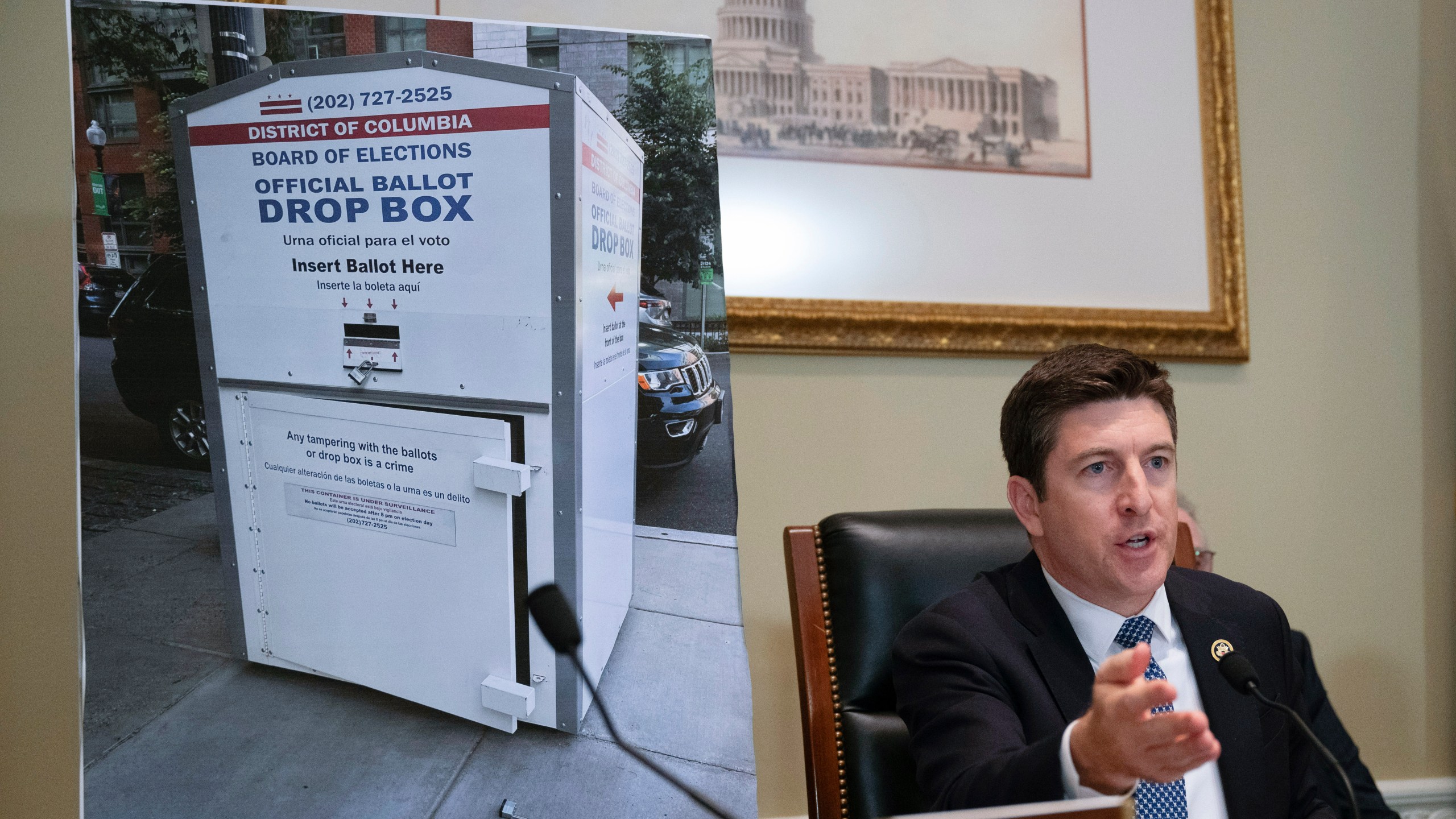 Bryan Steil, R-Wis., chairman of the Committee on House Administration, displays a large photo of an unlocked election ballot drop box in Washington, during a hearing about noncitizen voting in U.S. elections. on Capitol Hill, Thursday, May 16, 2024 in Washington. In recent months, the specter of noncitizens voting in the U.S. has erupted into a leading rallying cry for Republicans. (AP Photo/John McDonnell)