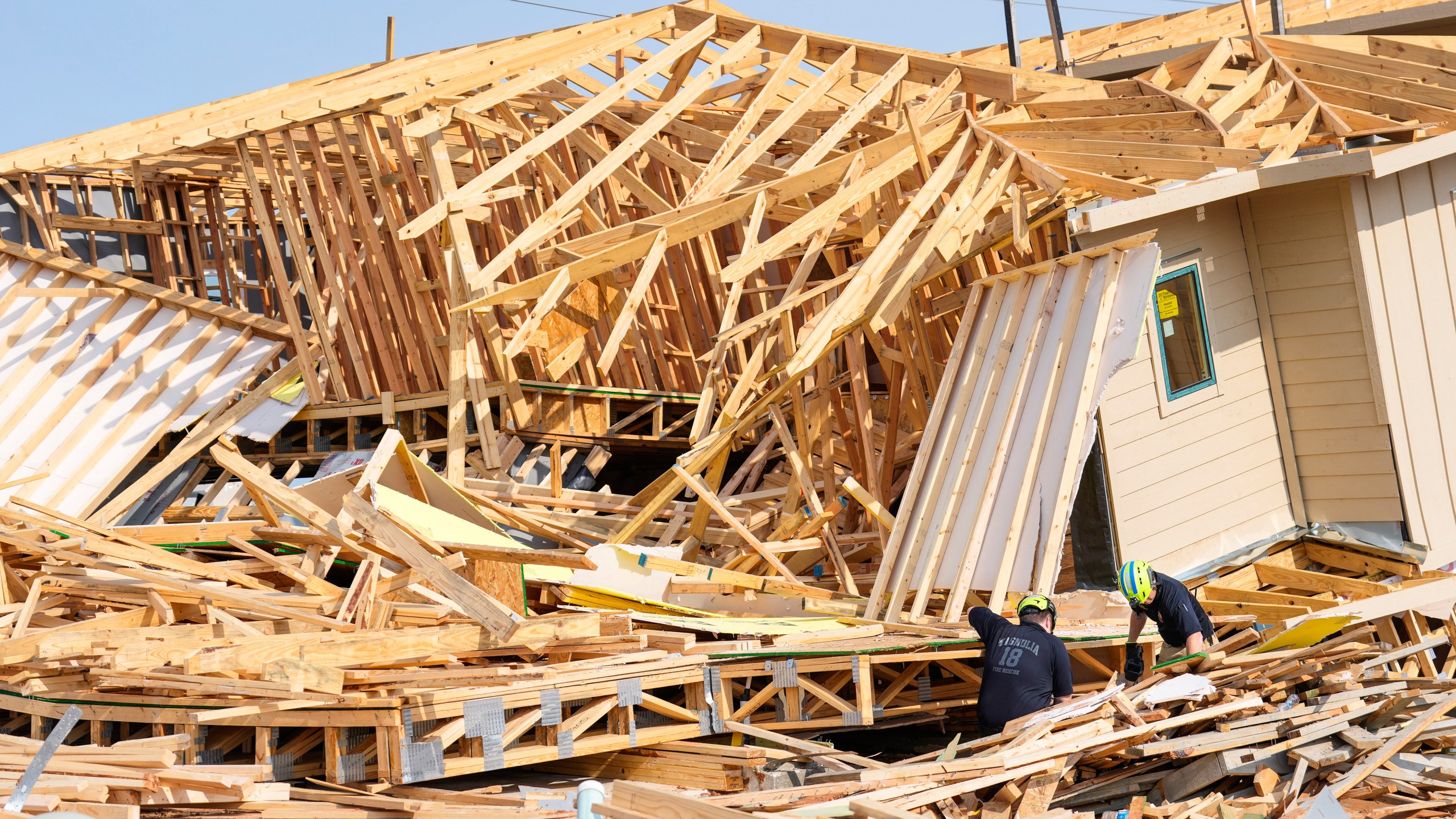 Magnolia Fire officials investigate the scene of a collapsed house that resulted in a fatality on Tuesday, May 28, 2024 in Magnolia, Texas. One construction worker was killed when the frames of two single-family homes that were under construction fell as a strong, fast-moving storm moved across Montgomery County, officials said. (Brett Coomer/Houston Chronicle via AP)