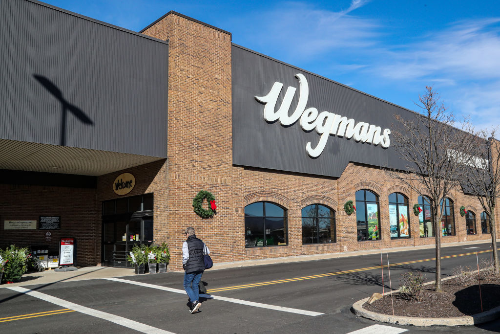 A woman is seen approaching the entrance of a Wegmans