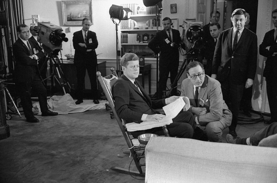 John F. Kennedy sits in a rocking chair in the White House