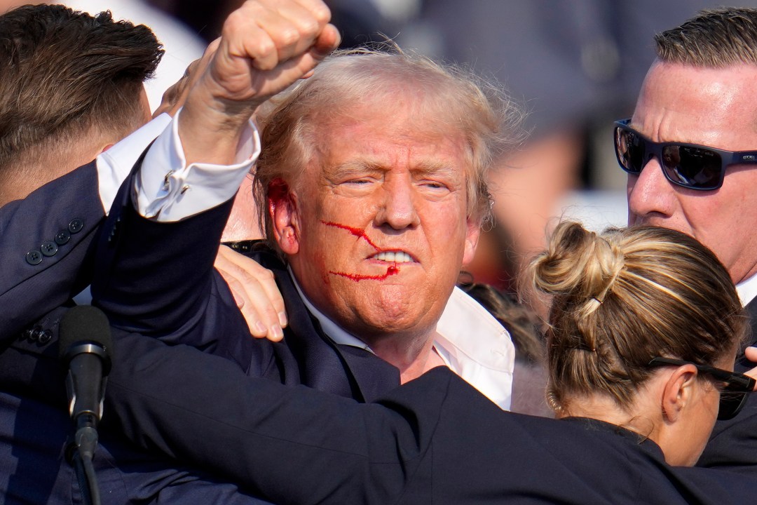 Republican presidential candidate former President Donald Trump reacts following an assassination attempt at a campaign event.