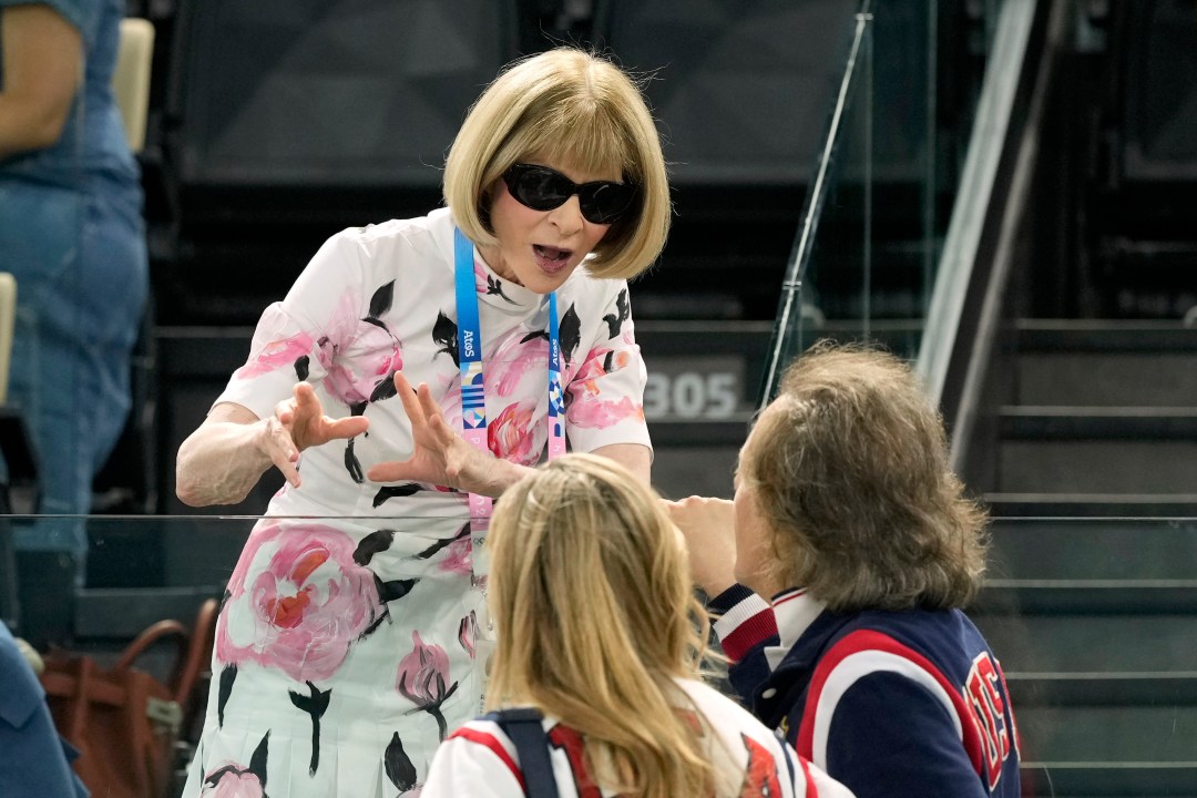 Anna Wintour, Vogue editor, speaks with attendees at the women's artistic gymnastics qualification round at the 2024 Summer Olympics, Sunday, July 28, 2024, in Paris, France. (AP Photo/Charlie Riedel)
