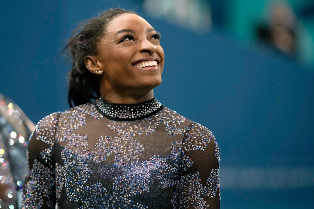 Simone Biles of United States, smiles after competing on the uneven bars during a women's artistic gymnastics qualification round at Bercy Arena at the 2024 Summer Olympics, Sunday, July 28, 2024, in Paris, France. (AP Photo/Charlie Riedel)