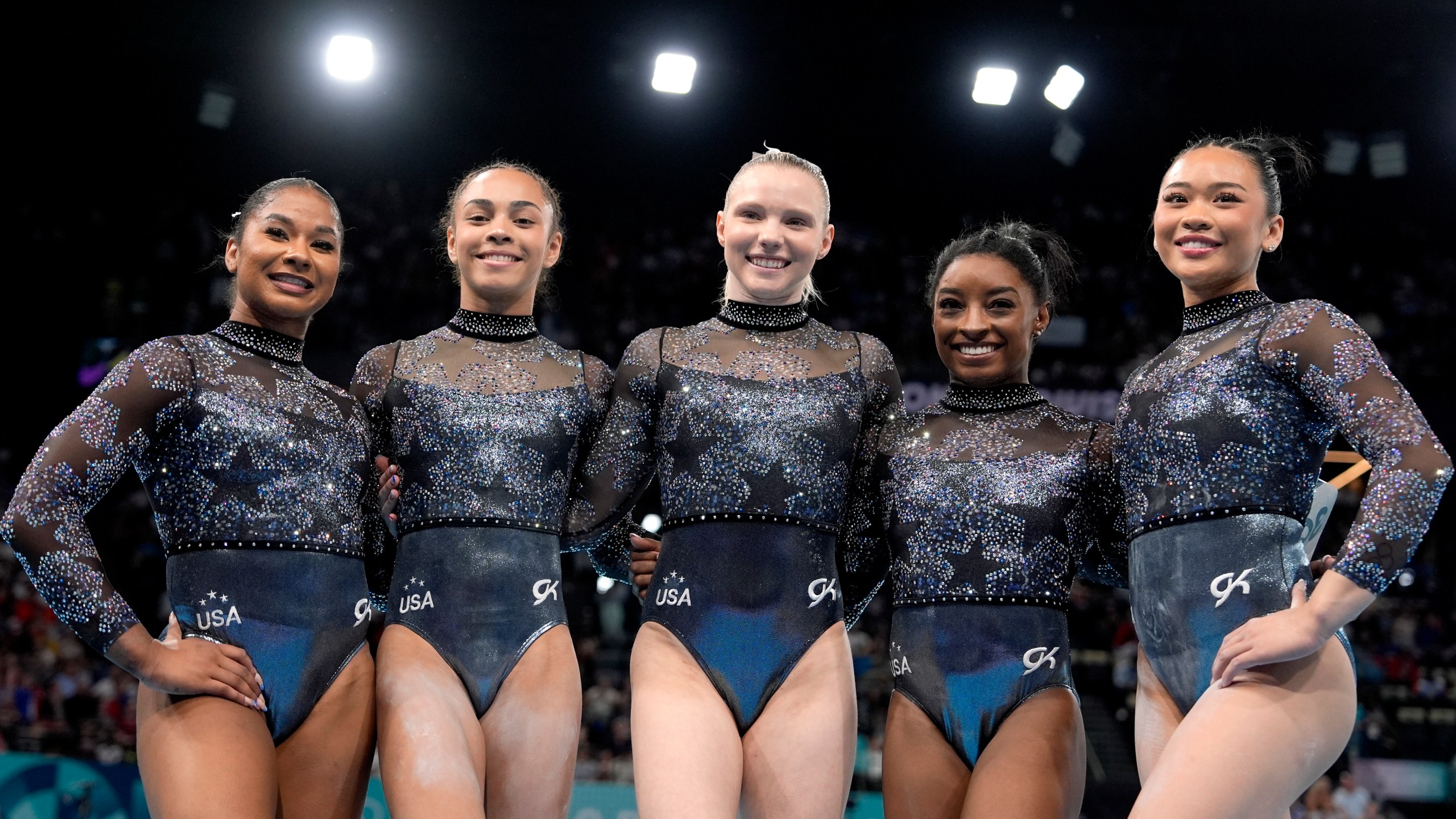 Team USA from left to right, Jordan Chiles, Hezly Rivera, Jade Carey, Simone Biles and Sunisa Lee, right, pose for photos after competing in a women's artistic gymnastics qualification round at Bercy Arena at the 2024 Summer Olympics, Sunday, July 28, 2024, in Paris, France. (AP Photo/Charlie Riedel)