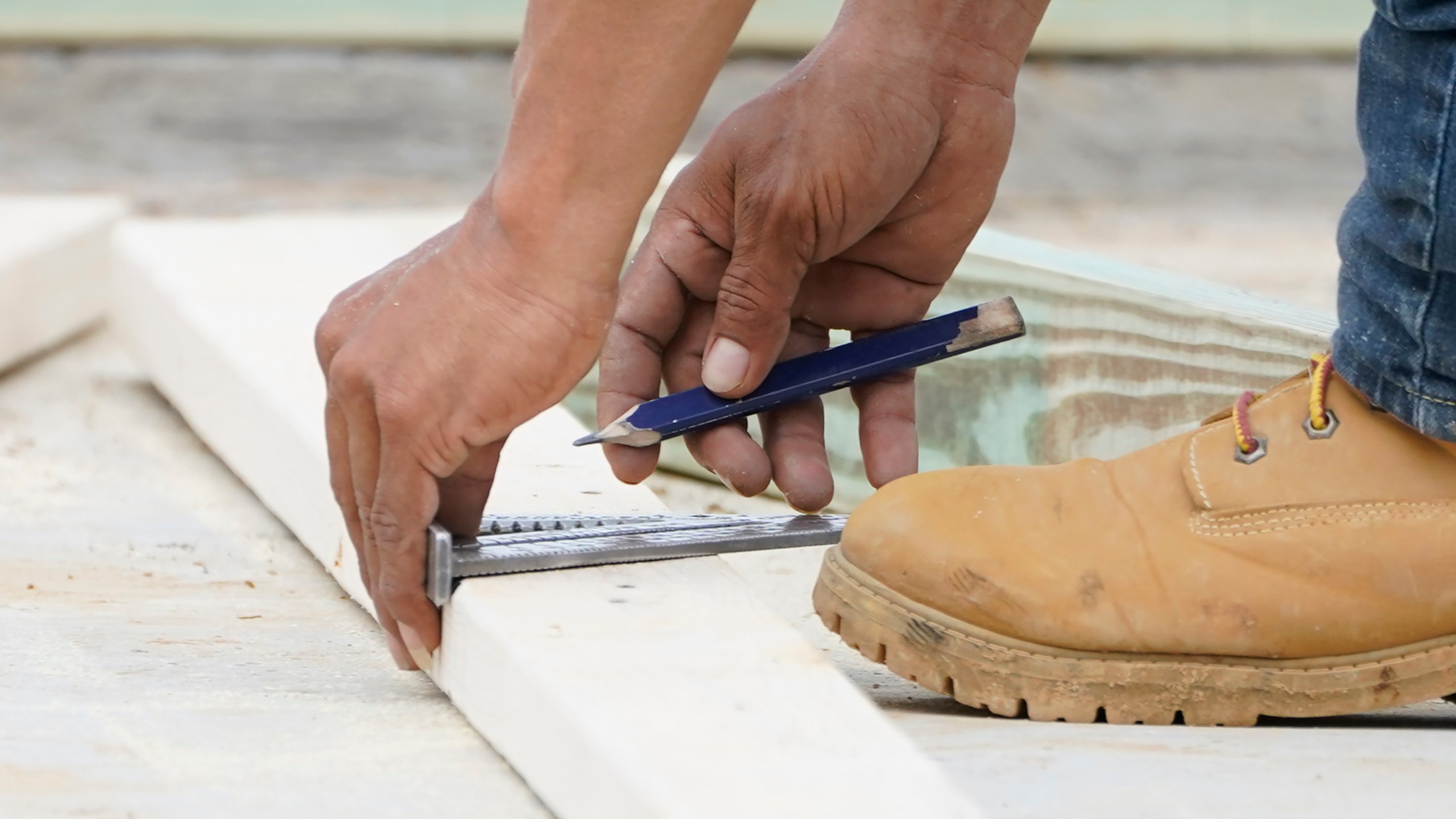 FILE - A workman measures a a piece of wood in Madison County, Miss., on March 16, 2021. Nearly one in three Americans earn money on the side in addition to working full time, a Bankrate survey found. (AP Photo/Rogelio V. Solis, File)