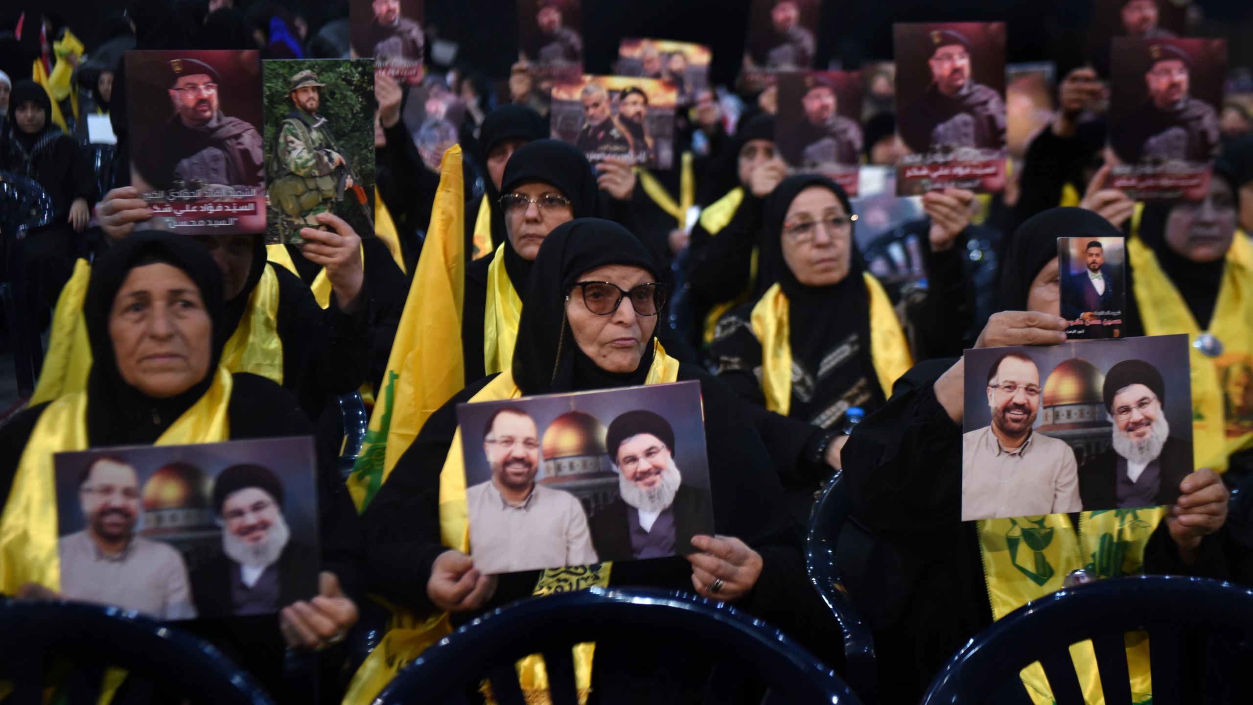 Hezbollah supporters hold portraits that show Hezbollah leader Sayyid Hassan Nasrallah and one of his commander Fouad Shukur, who was killed by an Israeli airstrike last week, during a ceremony to commemorate his death in Beirut, Lebanon, Tuesday, Aug. 6, 2024. (AP Photo/Mustafa Jamalddine)