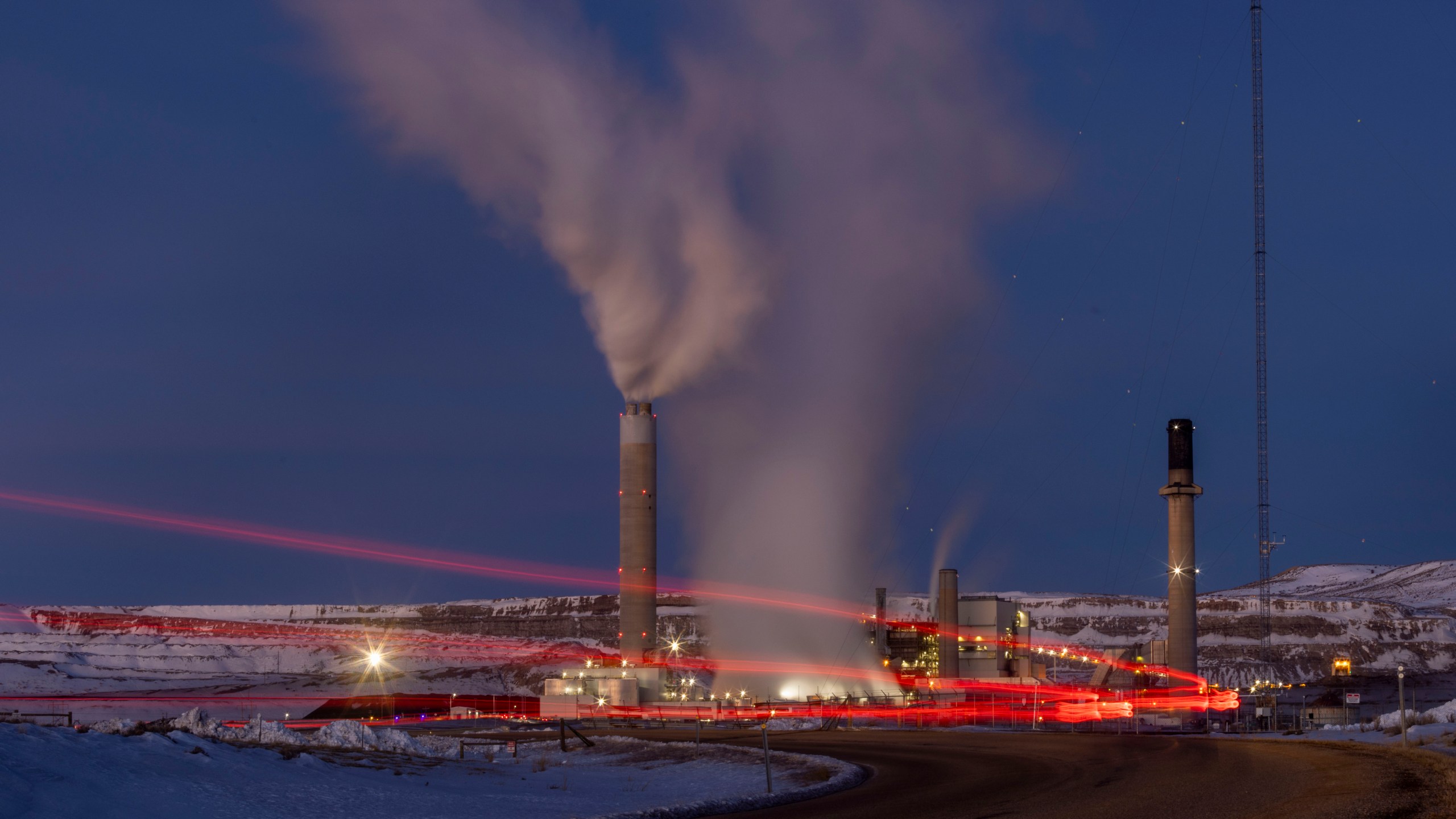 FILE - Taillights trace the path of a motor vehicle at the Naughton Power Plant, Jan. 13, 2022, in Kemmerer, Wyo., next to a site where Bill Gates and his energy company are starting construction on a next-generation nuclear plant. (AP Photo/Natalie Behring, File)