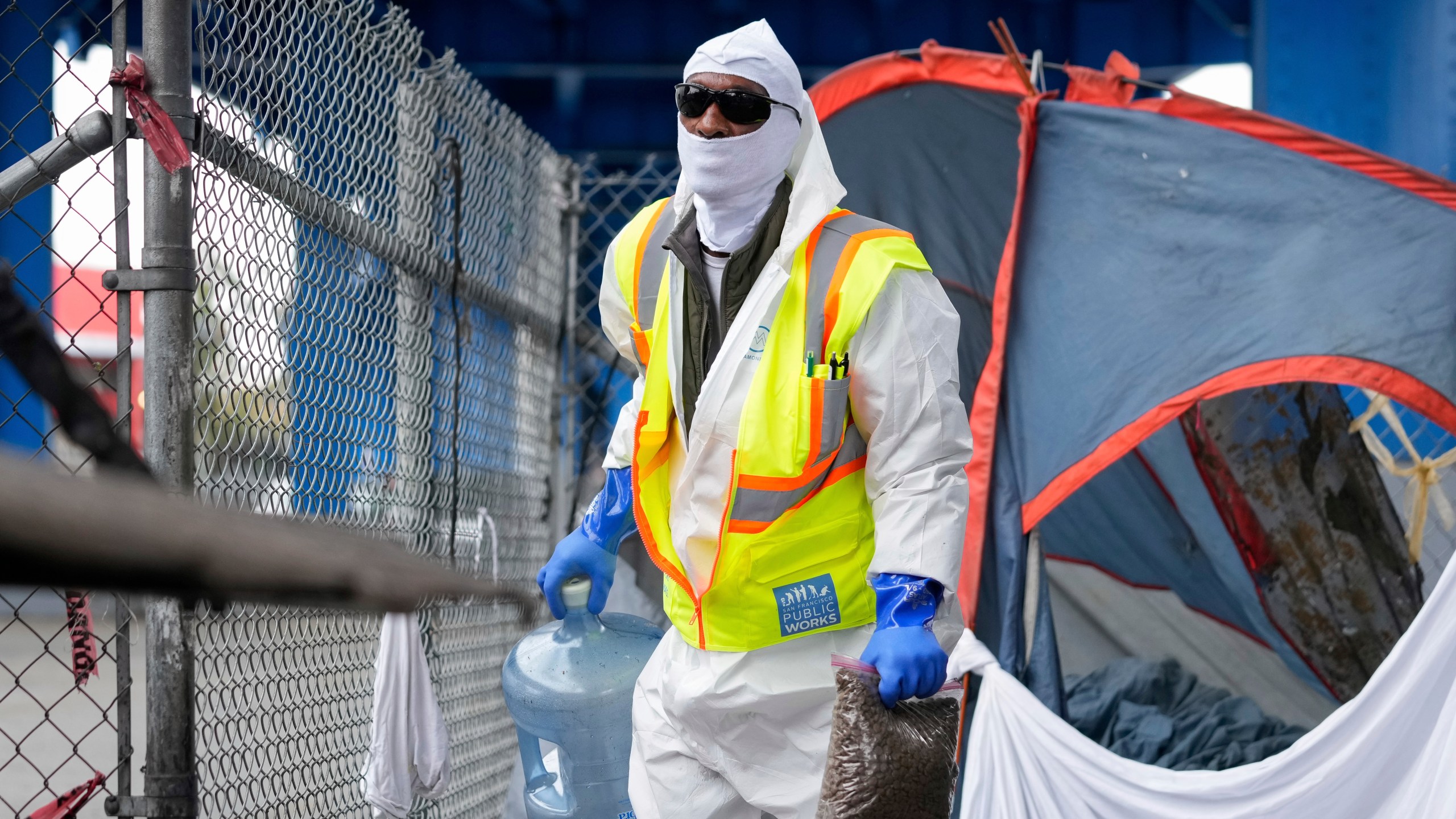 A member of San Francisco Public Works clears a homeless encampment Thursday, Aug. 1, 2024, in San Francisco. (AP Photo/Godofredo A. Vásquez)