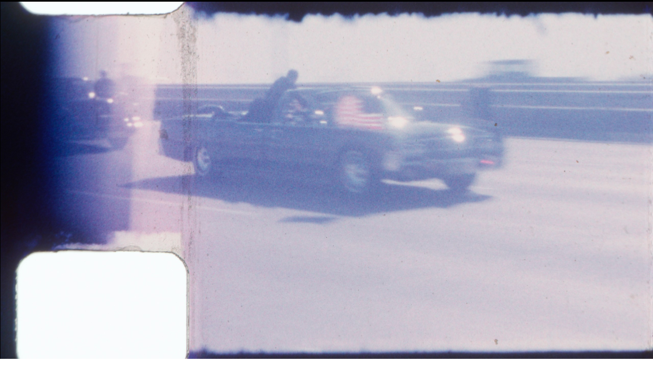 An undated image released by RR Auction shows home film footage of President John F. Kennedy's motorcade speeding down a Dallas freeway to the hospital after he was fatally wounded on Nov. 22, 1963. The image comes from a home film taken by Dale Carpenter Sr., which will go up for auction later this month. (RR Auction via AP)