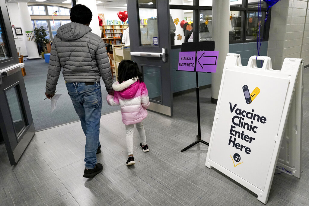 A child arrives with her parent to receive the Pfizer COVID-19 vaccine for children 5 to 11-years-old at London Middle School in Wheeling, Ill., Nov. 17, 2021. (AP Photo/Nam Y. Huh, File)