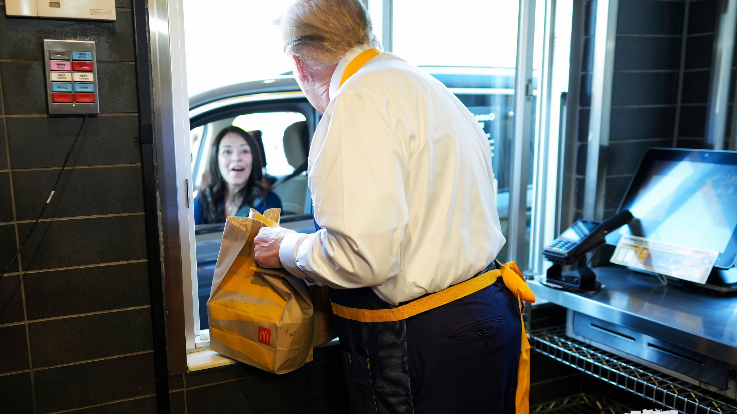 Republican presidential nominee former President Donald Trump hands an order to an employee at the drive-thru window during a visit to McDonald's in Feasterville-Trevose, Pa., Sunday, Oct. 20, 2024. (Doug Mills/The New York Times via AP, Pool)