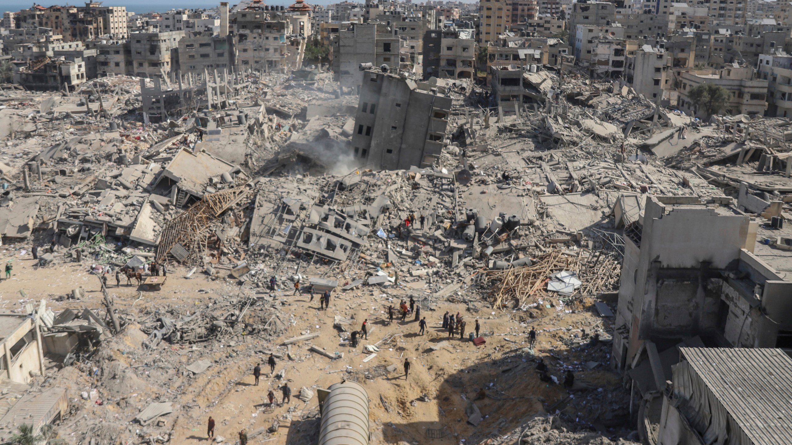 FILE - Palestinians walk through the destruction left by the Israeli air and ground offensive on the Gaza Strip near Shifa Hospital in Gaza City, on April 1, 2024. (AP Photo/Mohammed Hajjar, File)