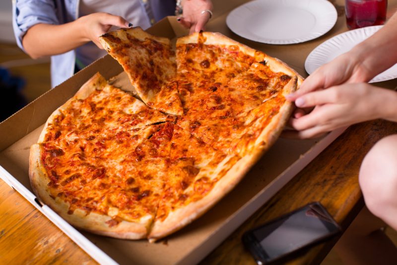 An image of people sharing a pizza