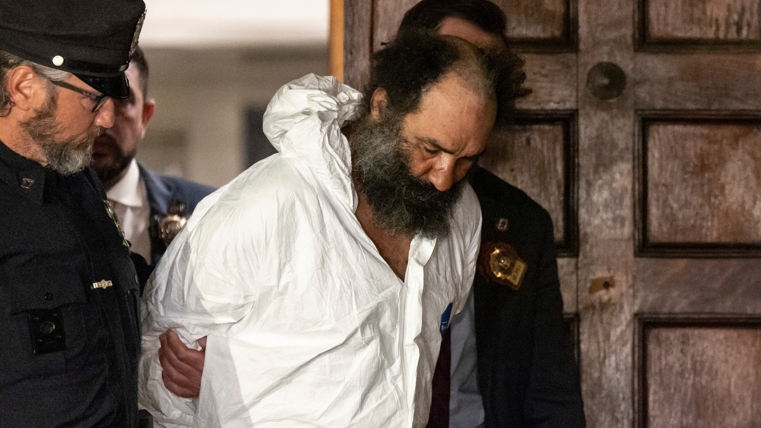 Ramon Rivera, a suspect arrested after multiple people were stabbed early Monday, is escorted out by NYPD officers at the NYPD 10th Precinct in New York, Monday, Nov. 18, 2024. (AP Photo/Yuki Iwamura)