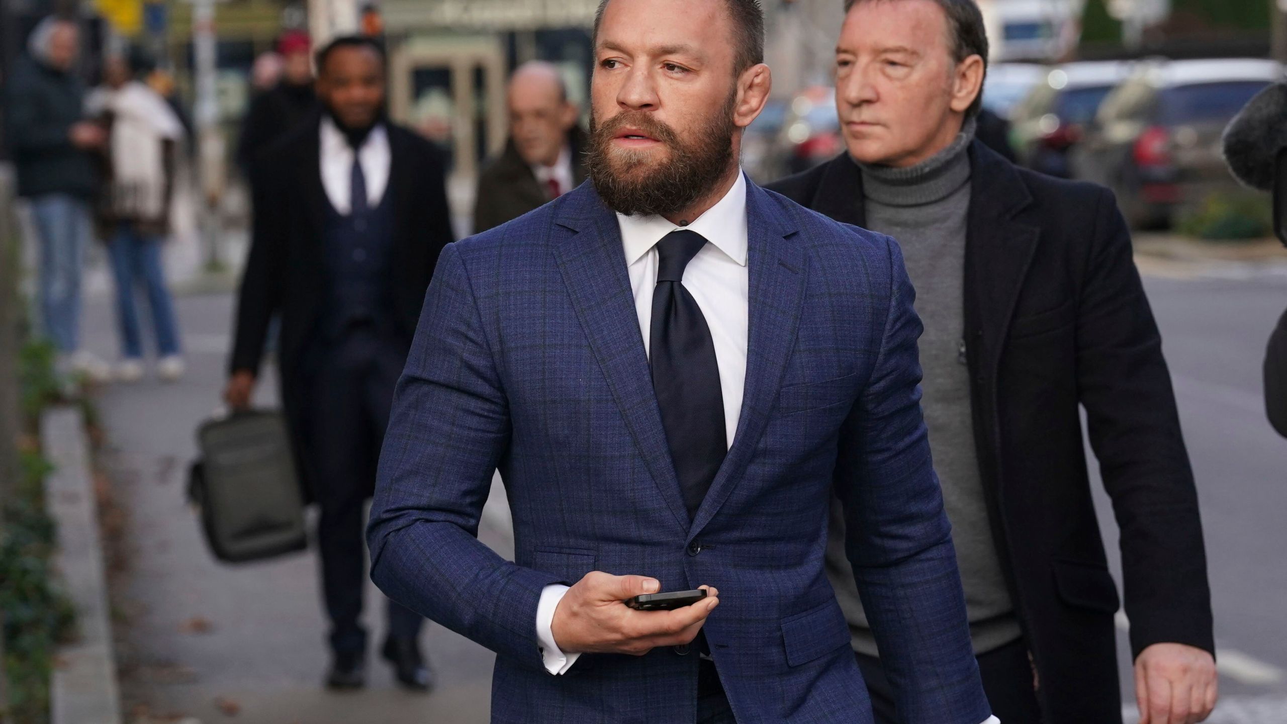 Mixed martial arts fighter Conor McGregor, front, and his father Tony, right, outside the High Court in Dublin, Ireland, Thursday, Nov. 21, 2024. (Brian Lawless/PA via AP)