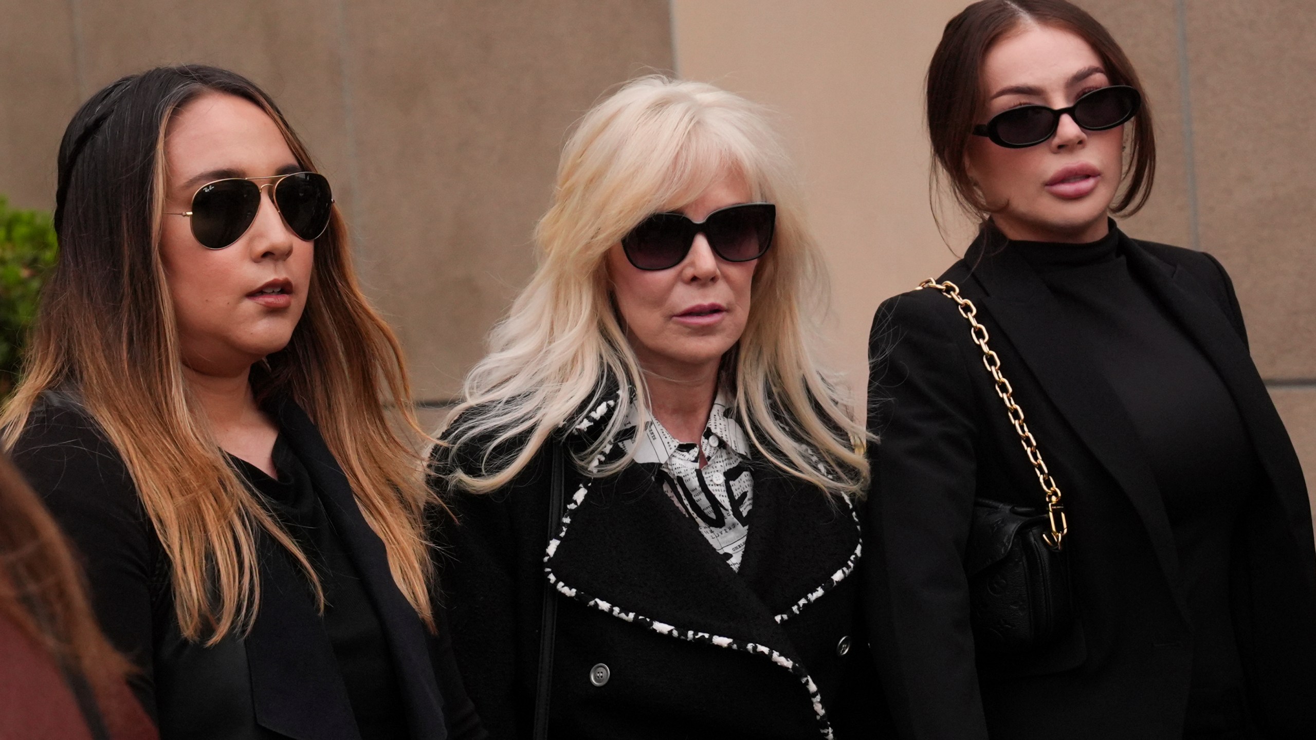 Tammi Menendez, center, the wife of Eric Menendez, leaves a courthouse after a hearing in Los Angeles,