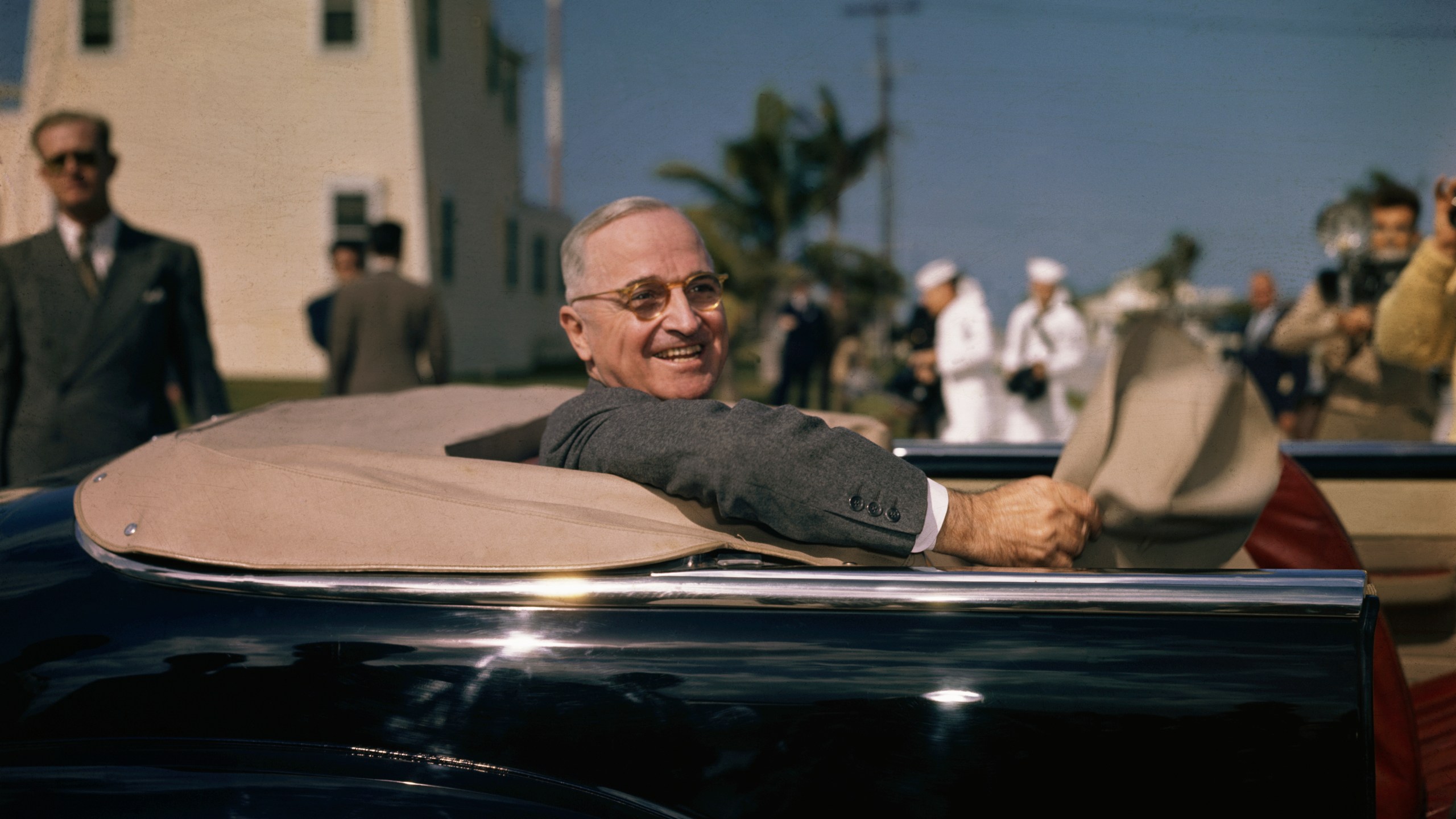 President Harry S. Truman chats from an open-top car in Key West, Florida in 1947.