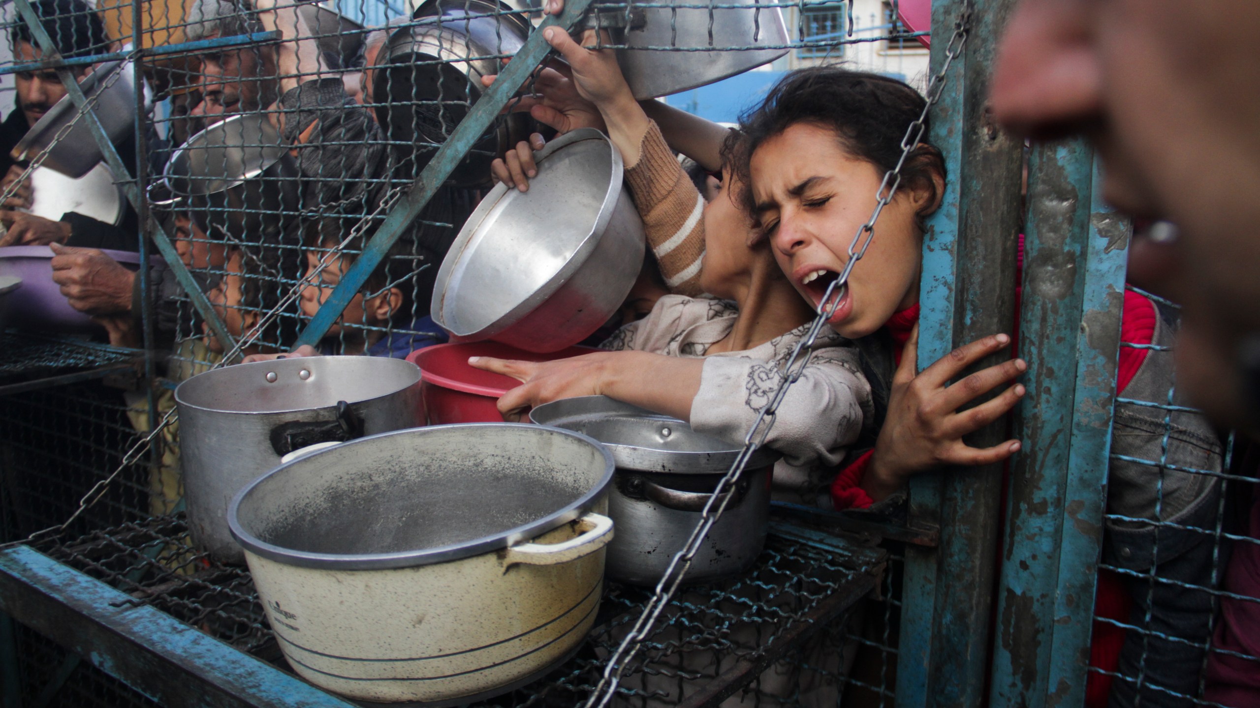 FILE - Palestinians line up to receive free meals at Jabaliya refugee camp in the Gaza Strip on March 18, 2024. (AP Photo/Mahmoud Essa, File)
