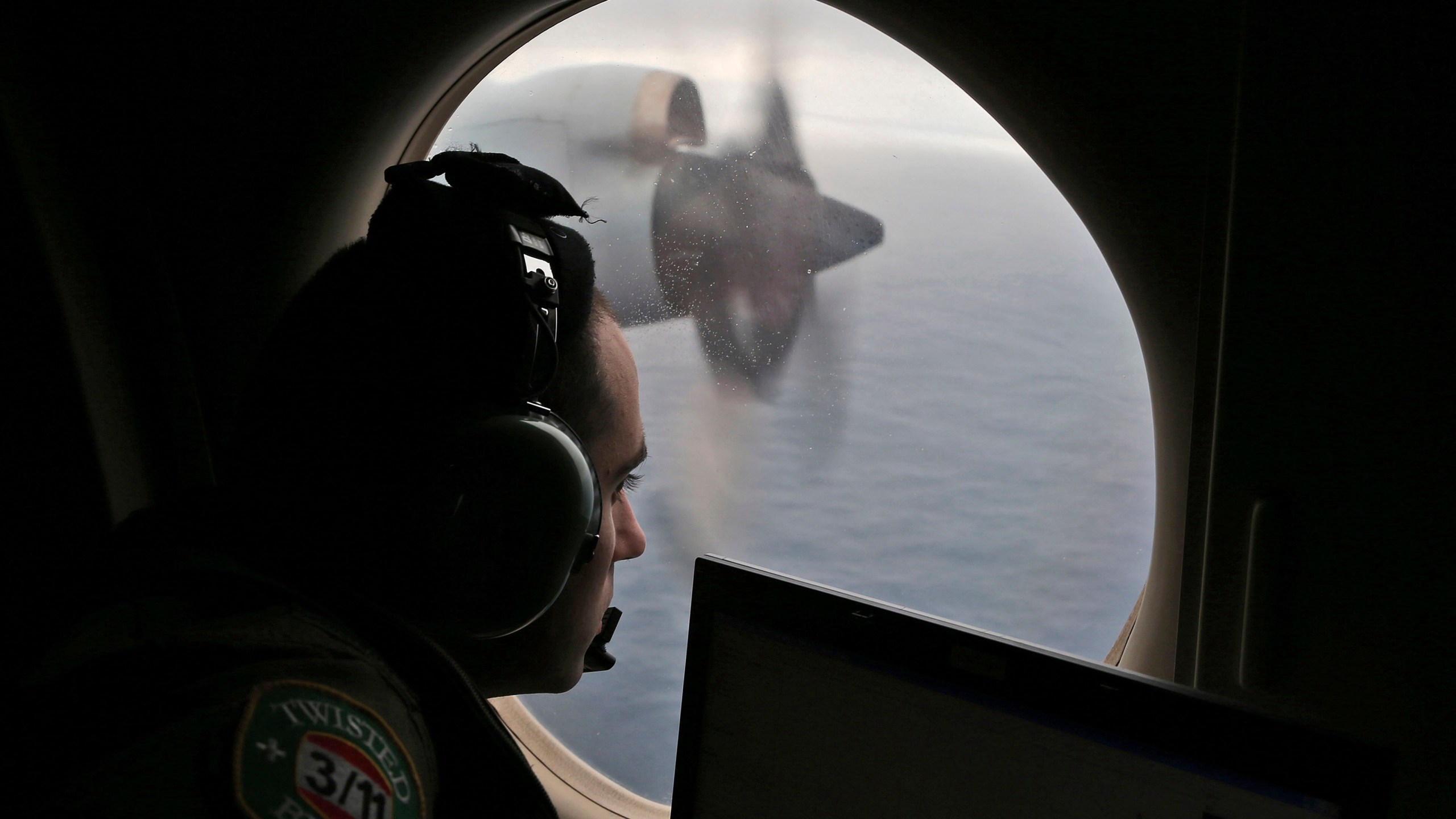 Flight officer Rayan Gharazeddine scans the water in the southern Indian Ocean off Australia from a Royal Australian Air Force AP-3C Orion during a search for the missing Malaysia Airlines Flight MH370, March 22, 2014. (AP Photo/Rob Griffith, File)