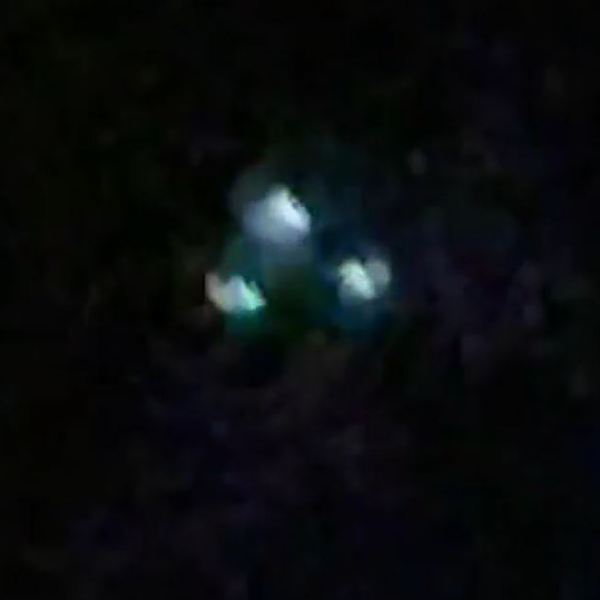 A picture of three lights in the sky in a triangular formation.
