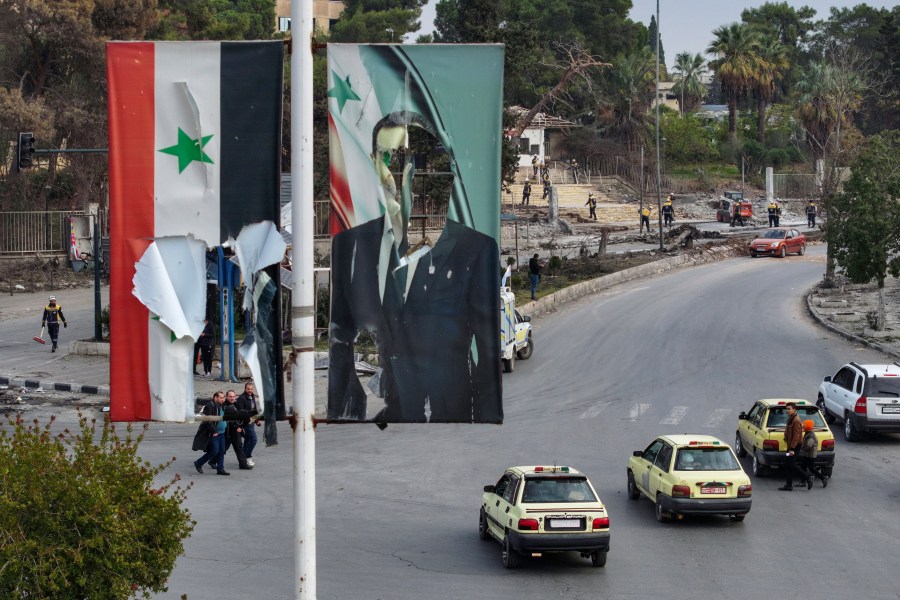 An aerial picture shows members of Syria's White Helmets civil defense service clearing vehicle carcasses.